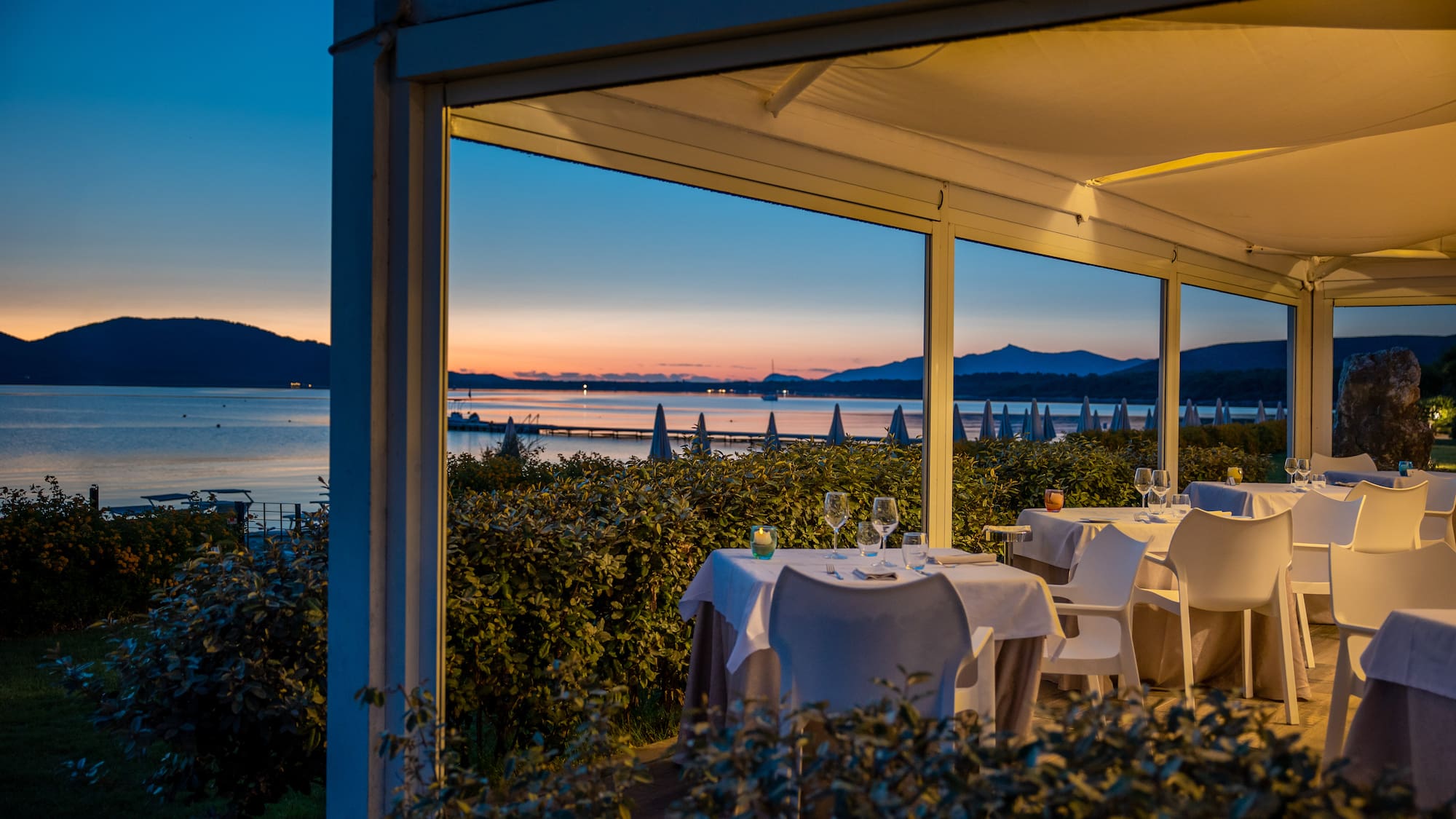 a table set up outside with a view of the ocean and mountains