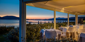 a table set up outside with a view of the ocean and mountains