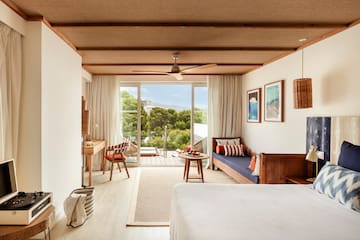 a room with a bed and a table and chairs