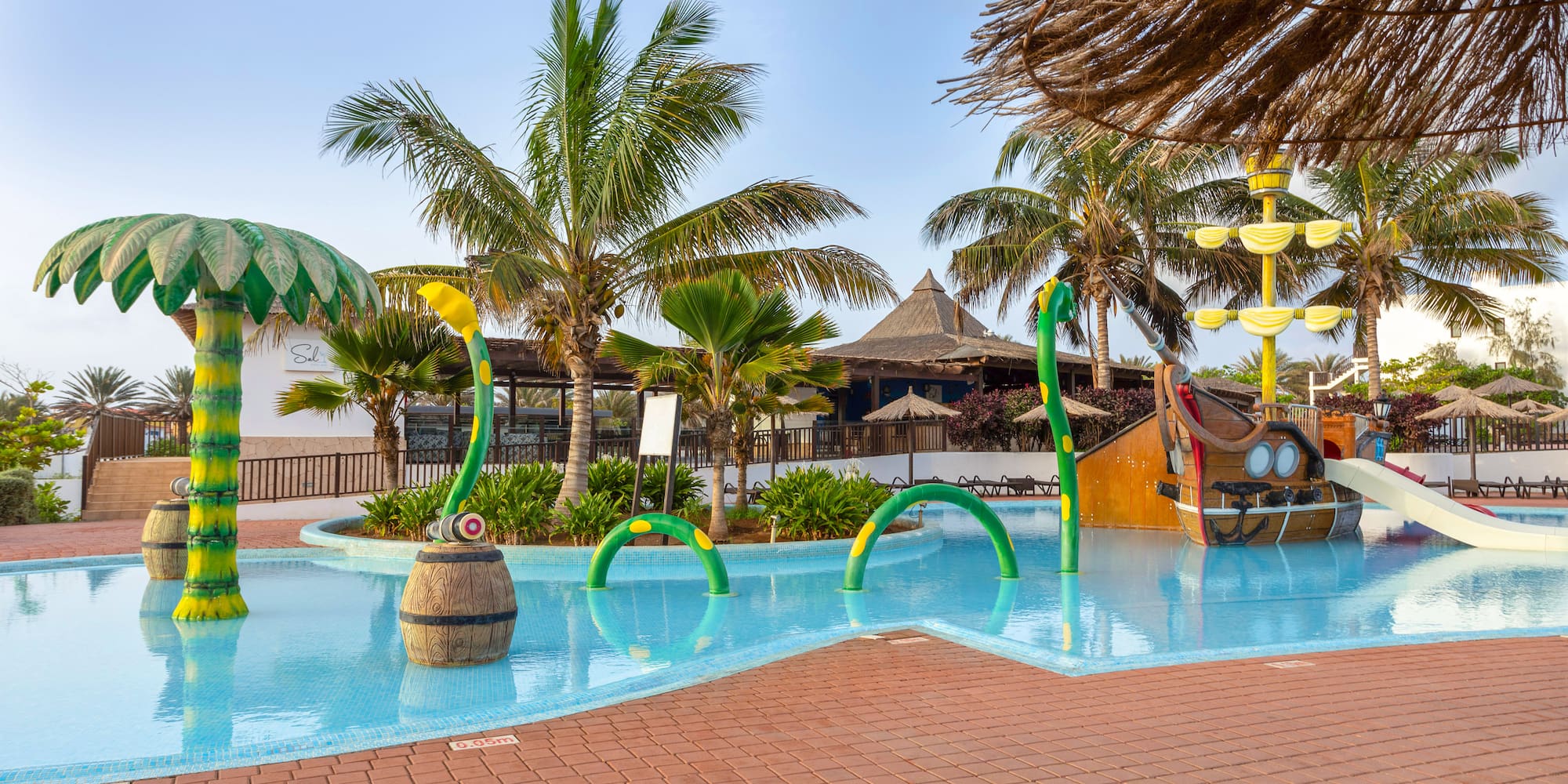 a pool with a water slide and a boat