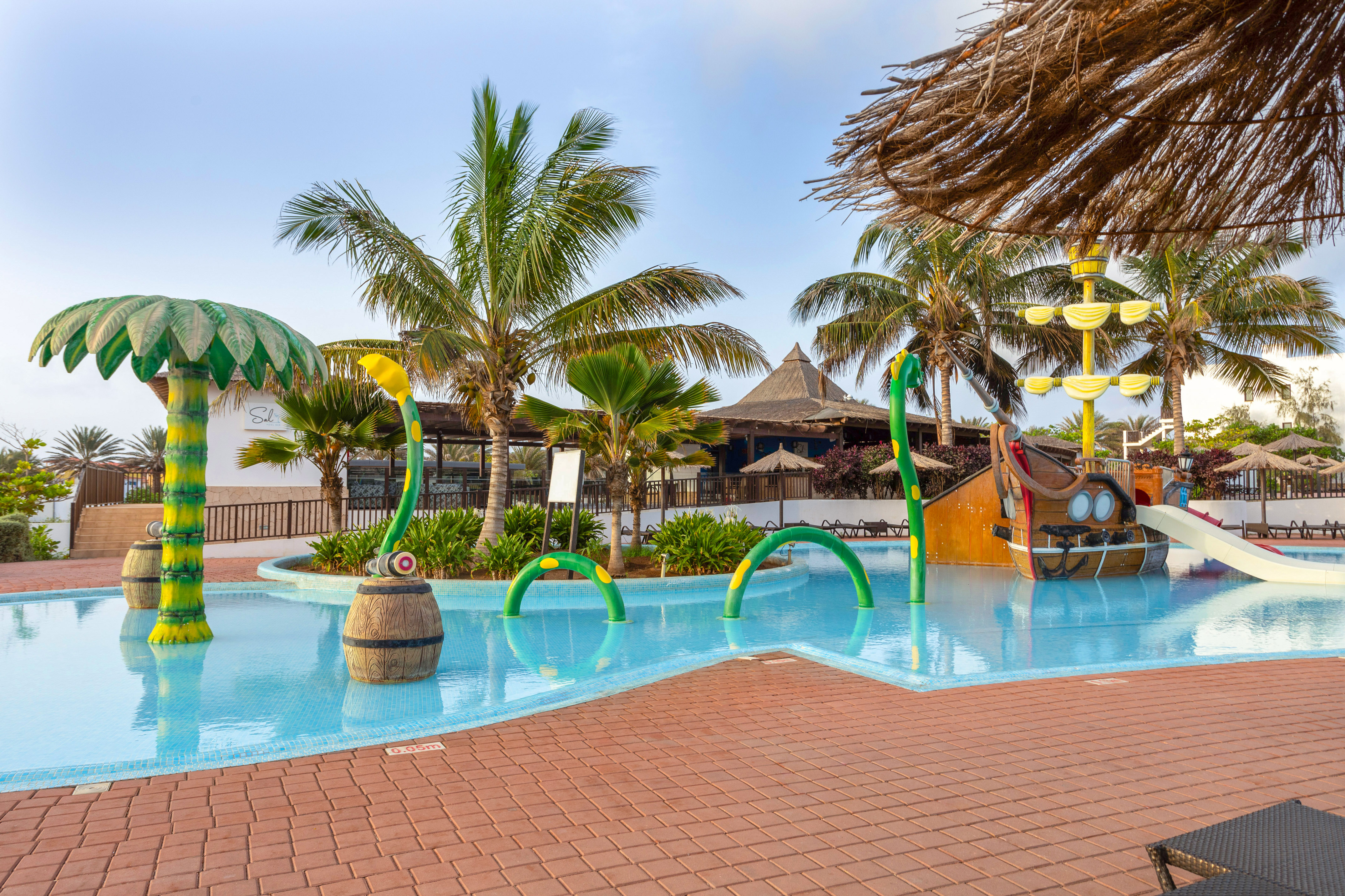 a pool with a water slide and a boat
