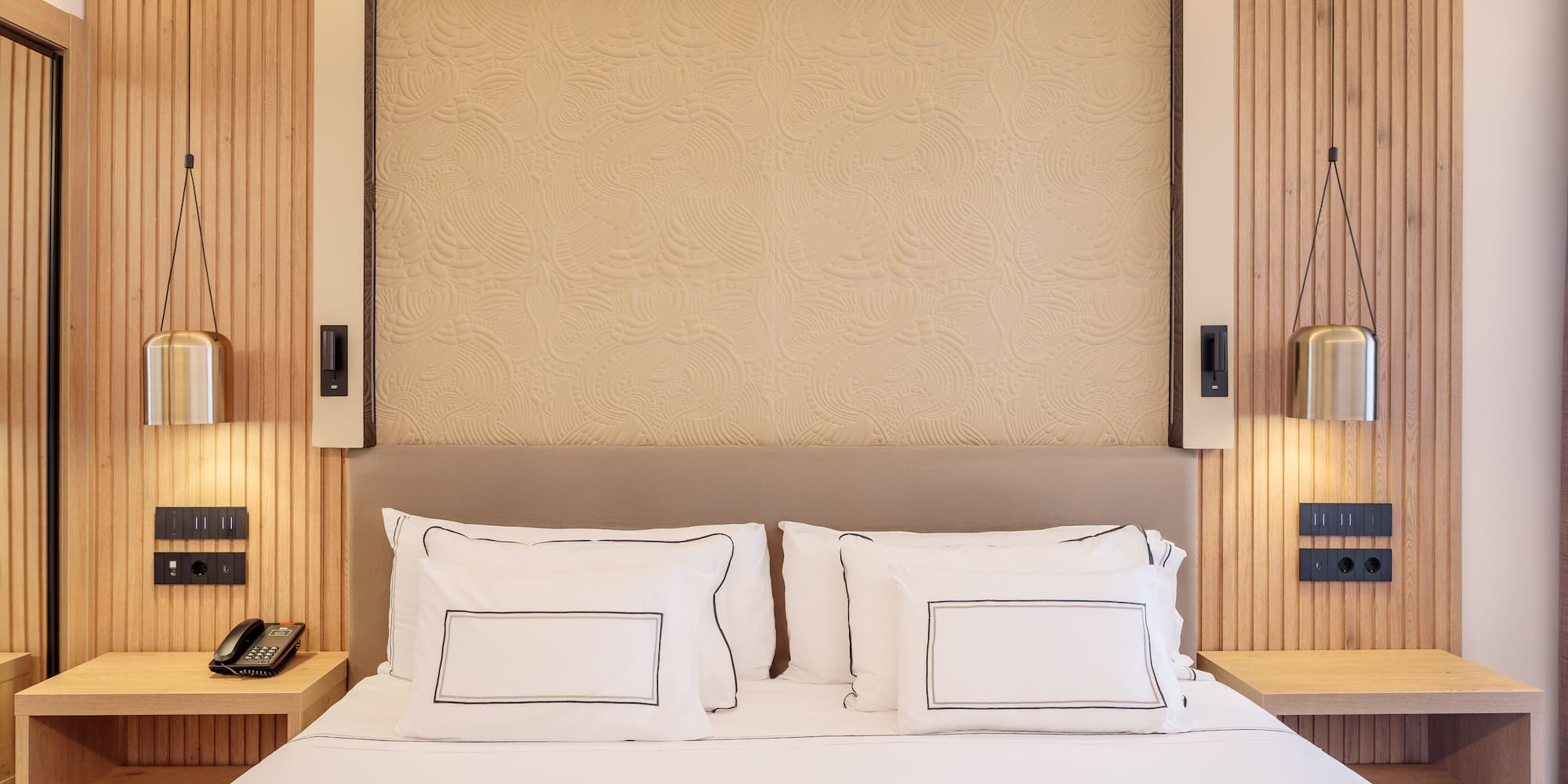 a bed with white sheets and pillows