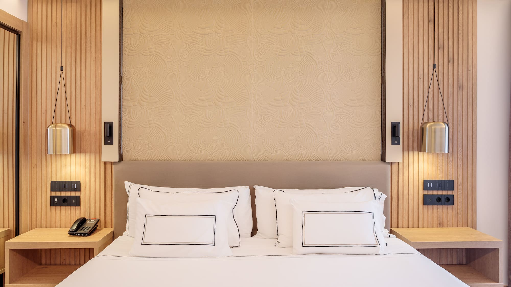 a bed with white sheets and pillows