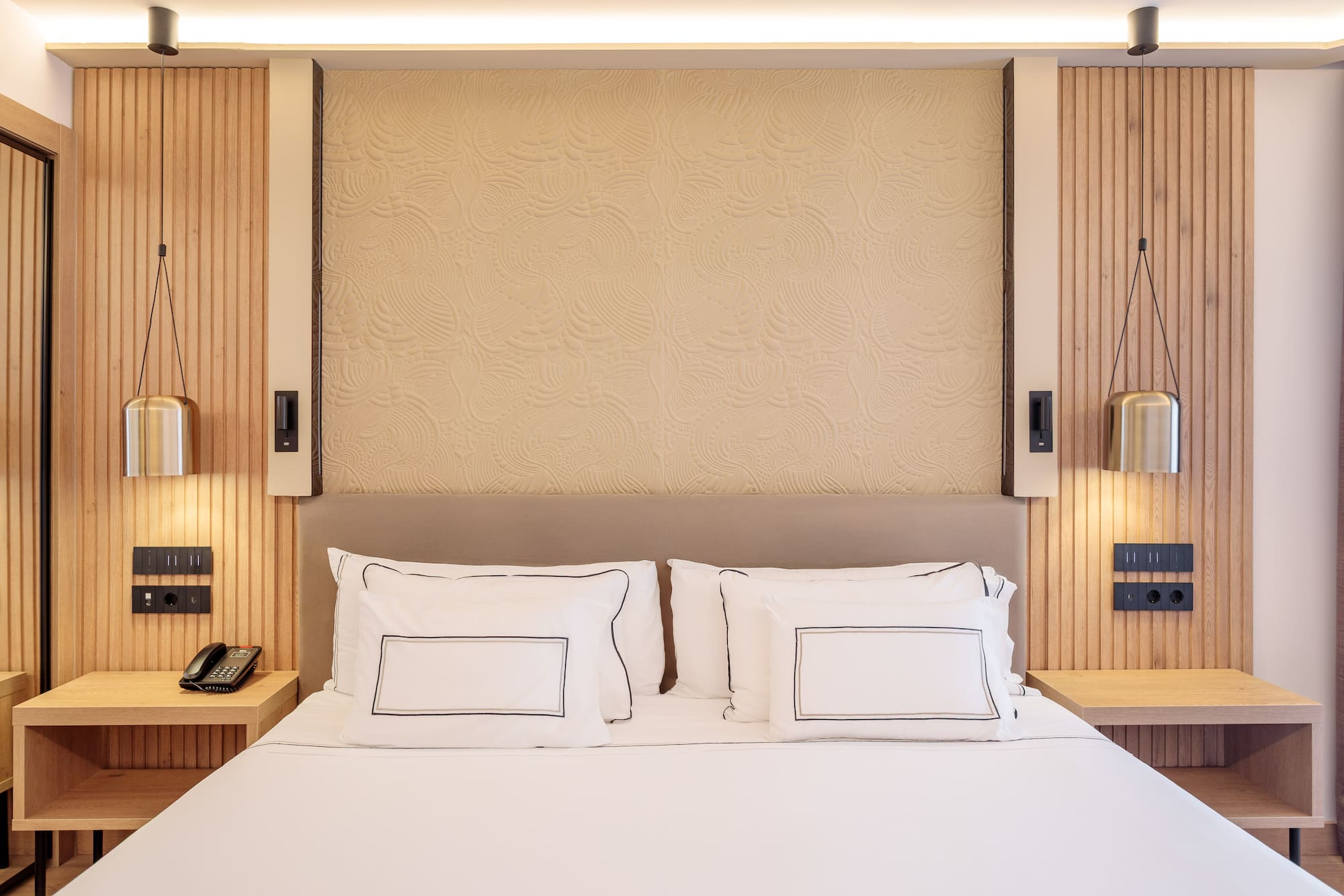 a bed with white sheets and pillows