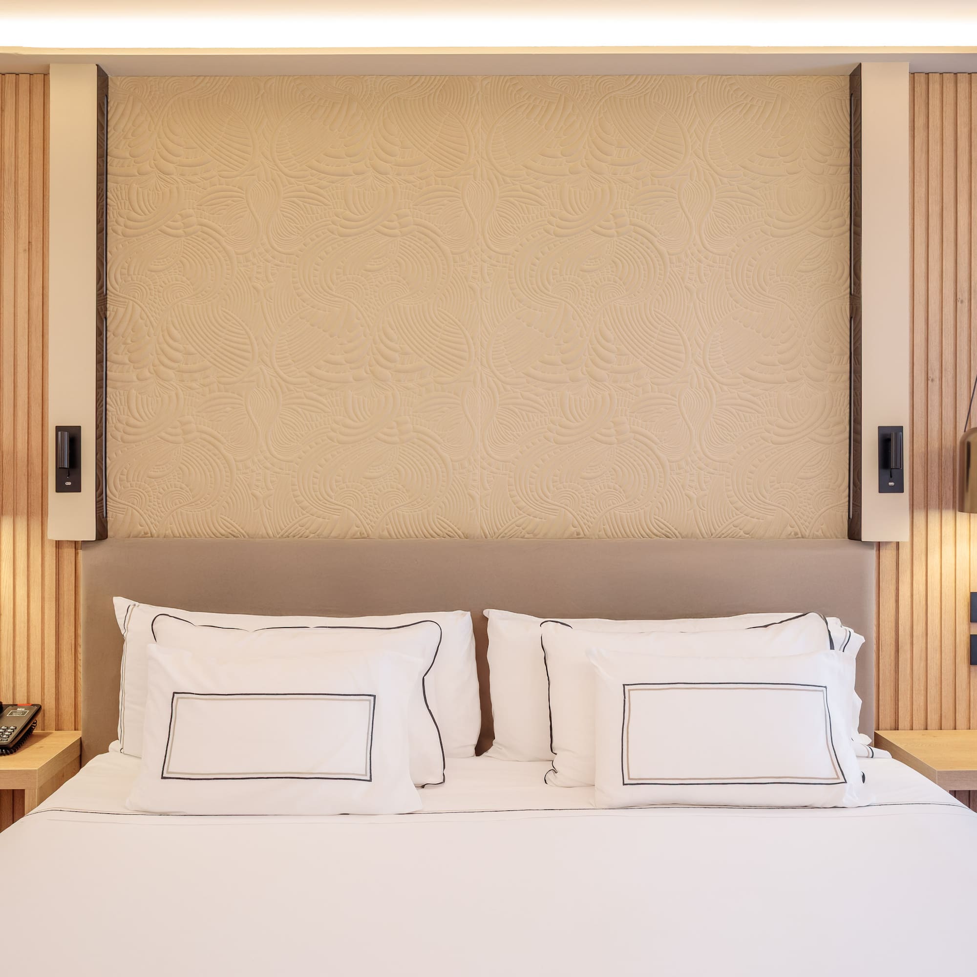 a bed with white sheets and pillows