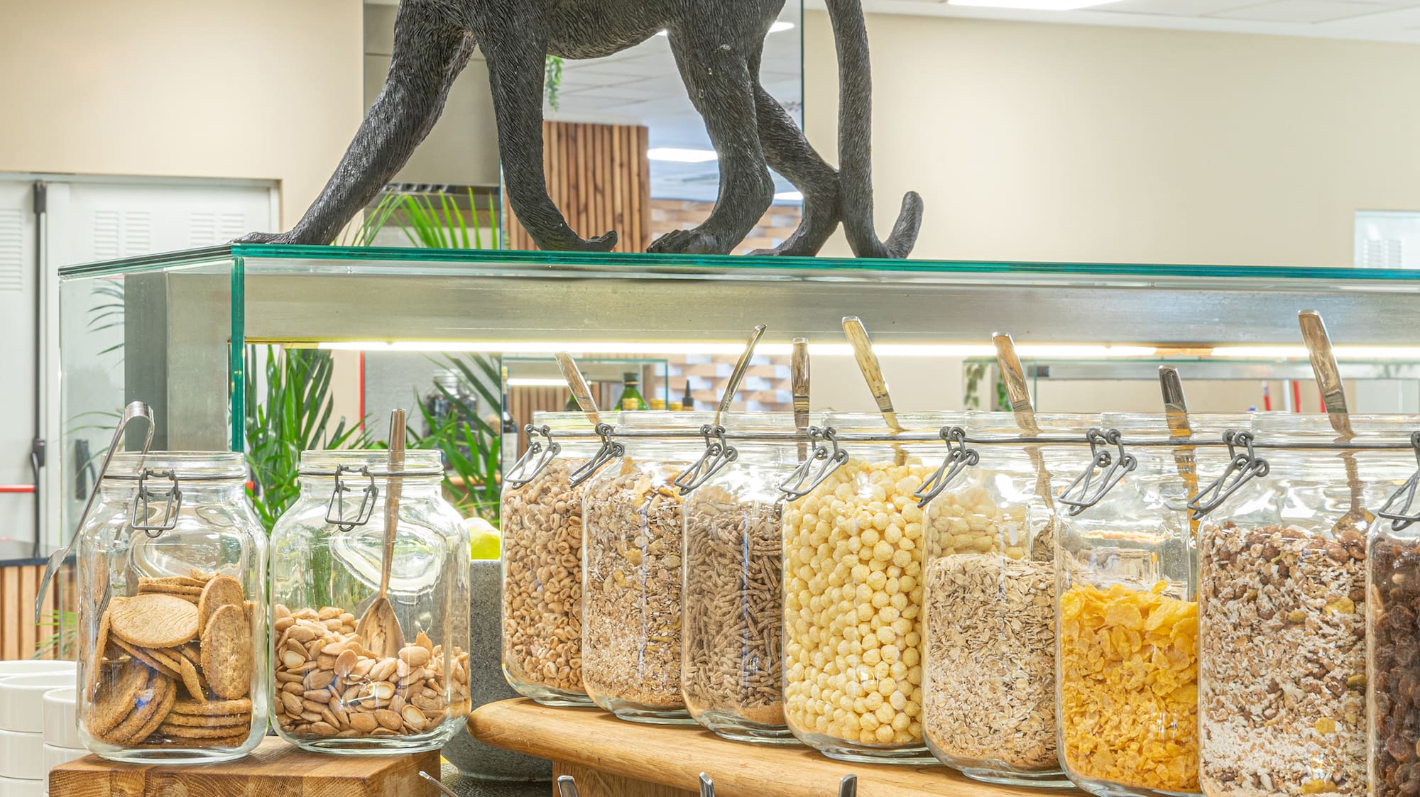 a shelf with jars of food and a statue of a monkey