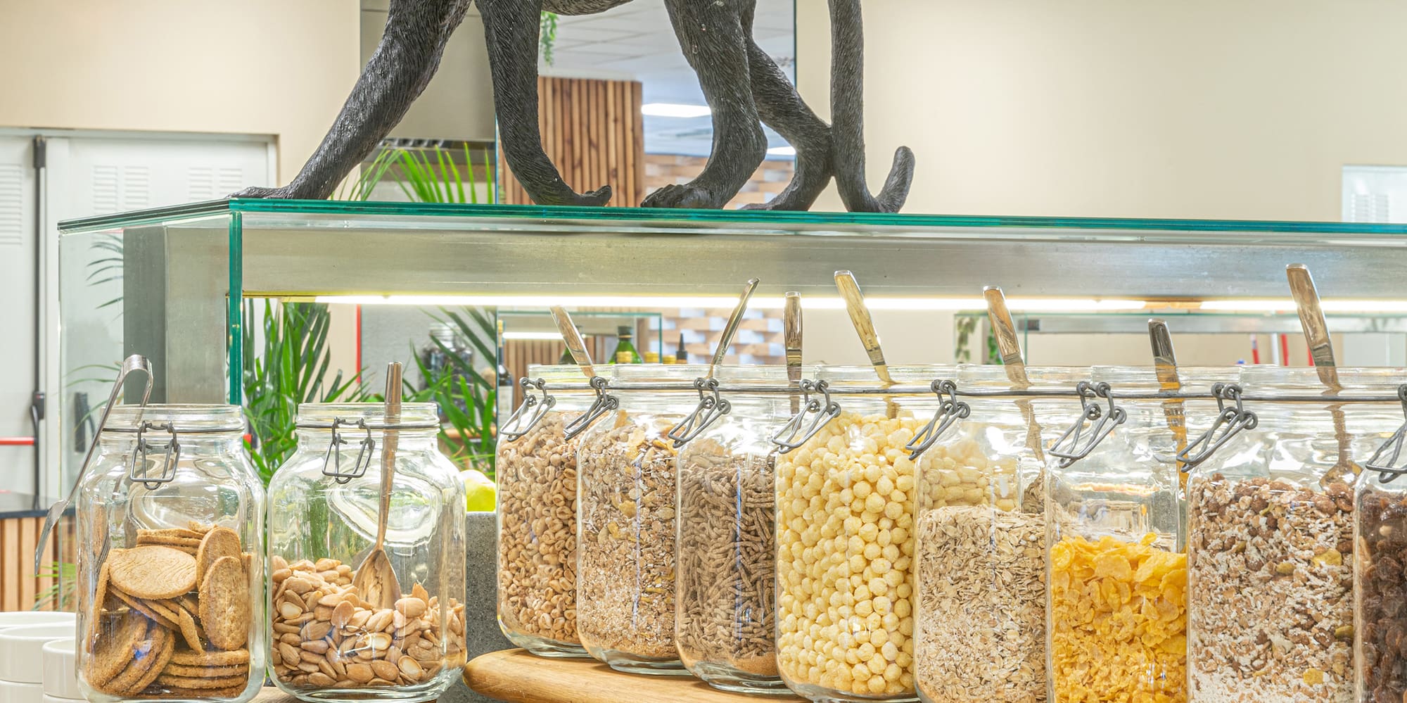 a shelf with jars of food and a statue of a monkey