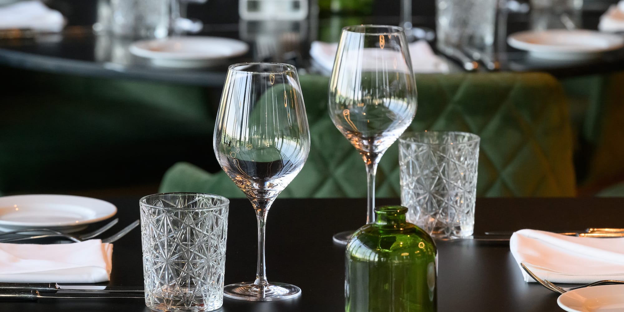 a table with glasses and a green bottle
