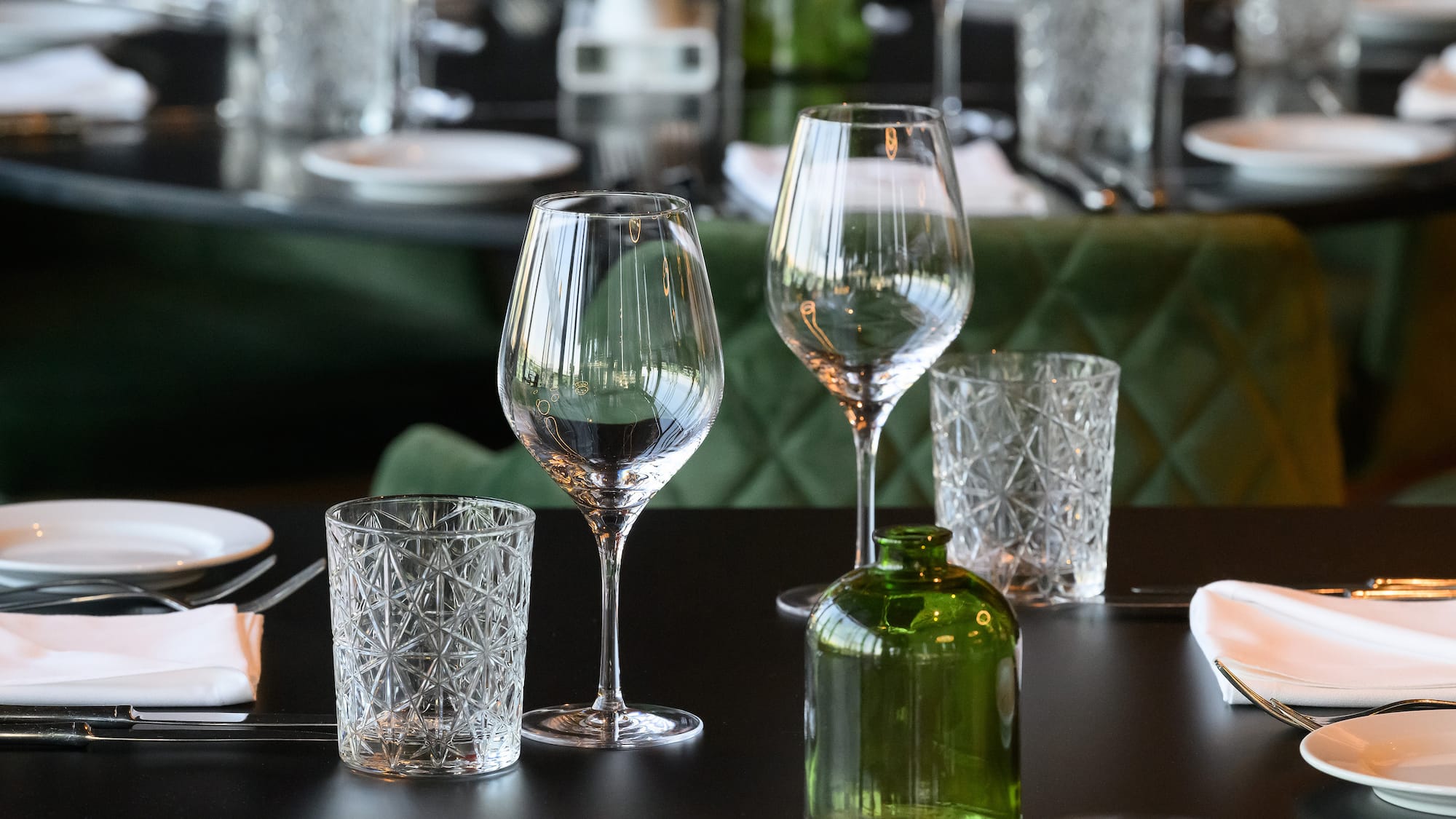 a table with glasses and a green bottle