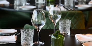 a table with glasses and a green bottle