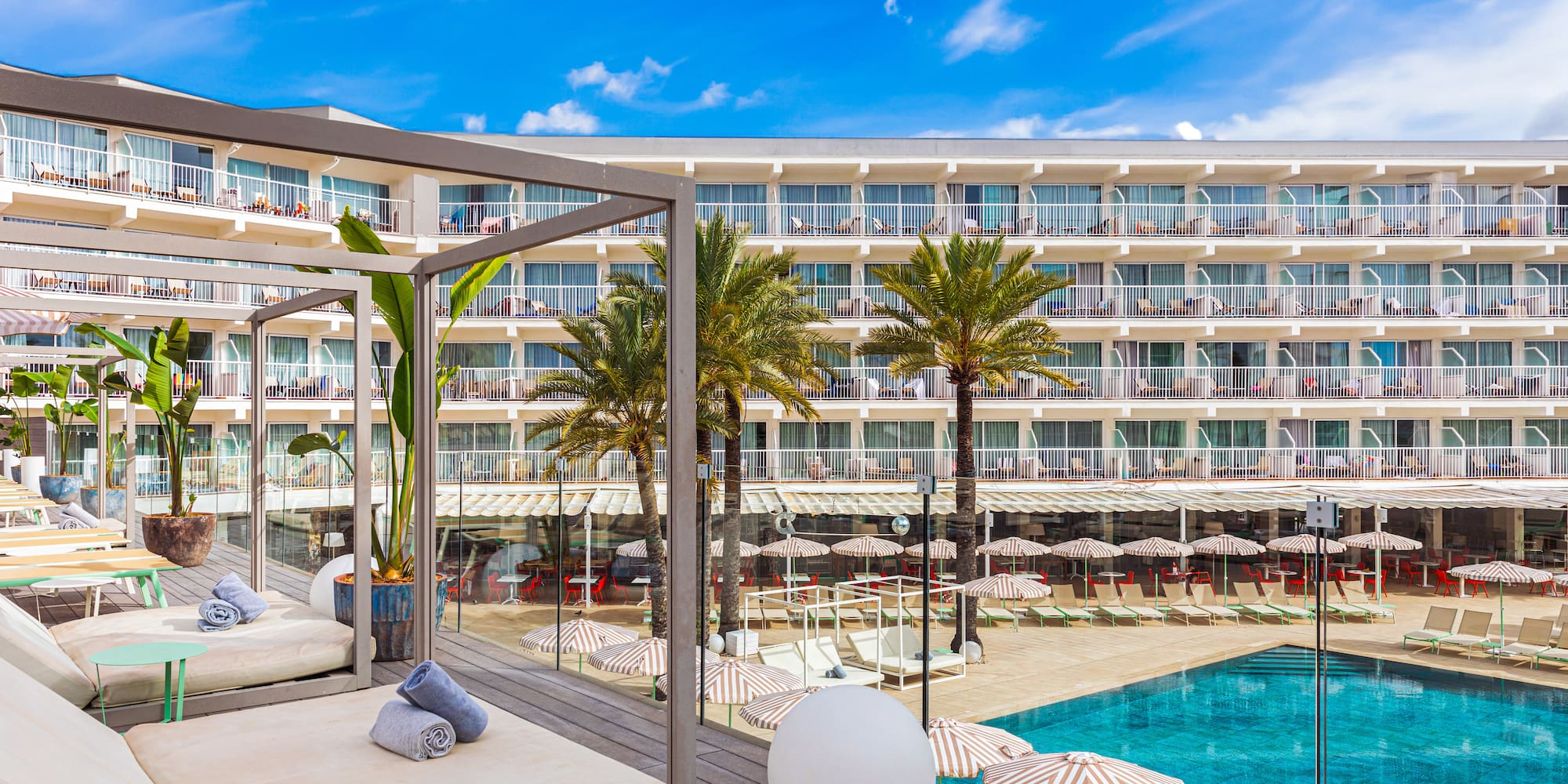 a pool with a large building and a lounge chair