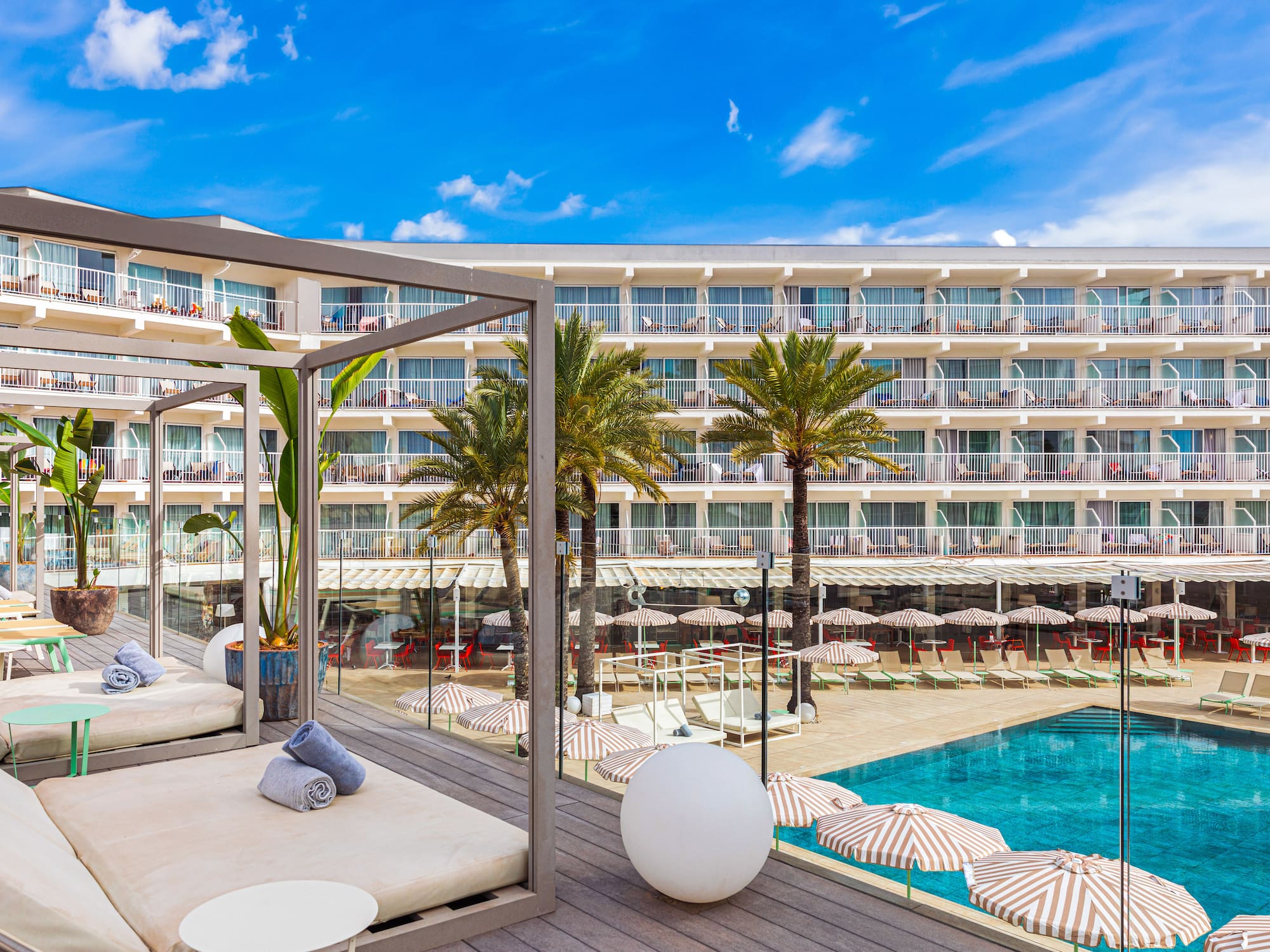 a pool with a large building and a lounge chair