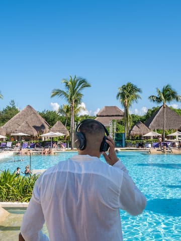 a man wearing headphones and standing in front of a pool