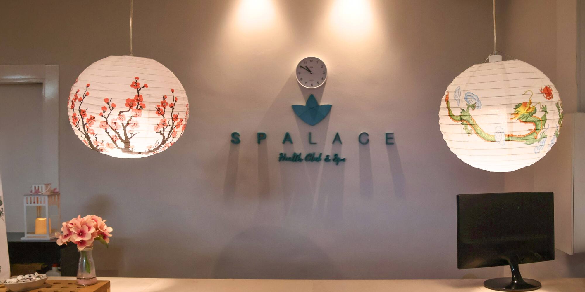 a white paper lanterns on a wall with a clock