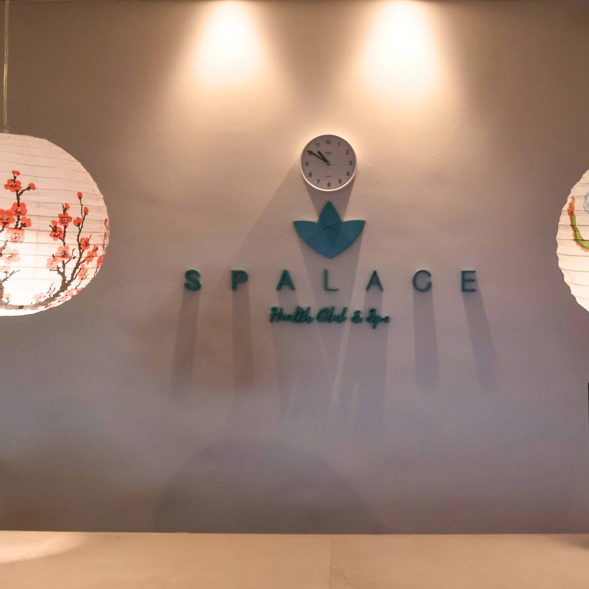 a white paper lanterns on a wall with a clock