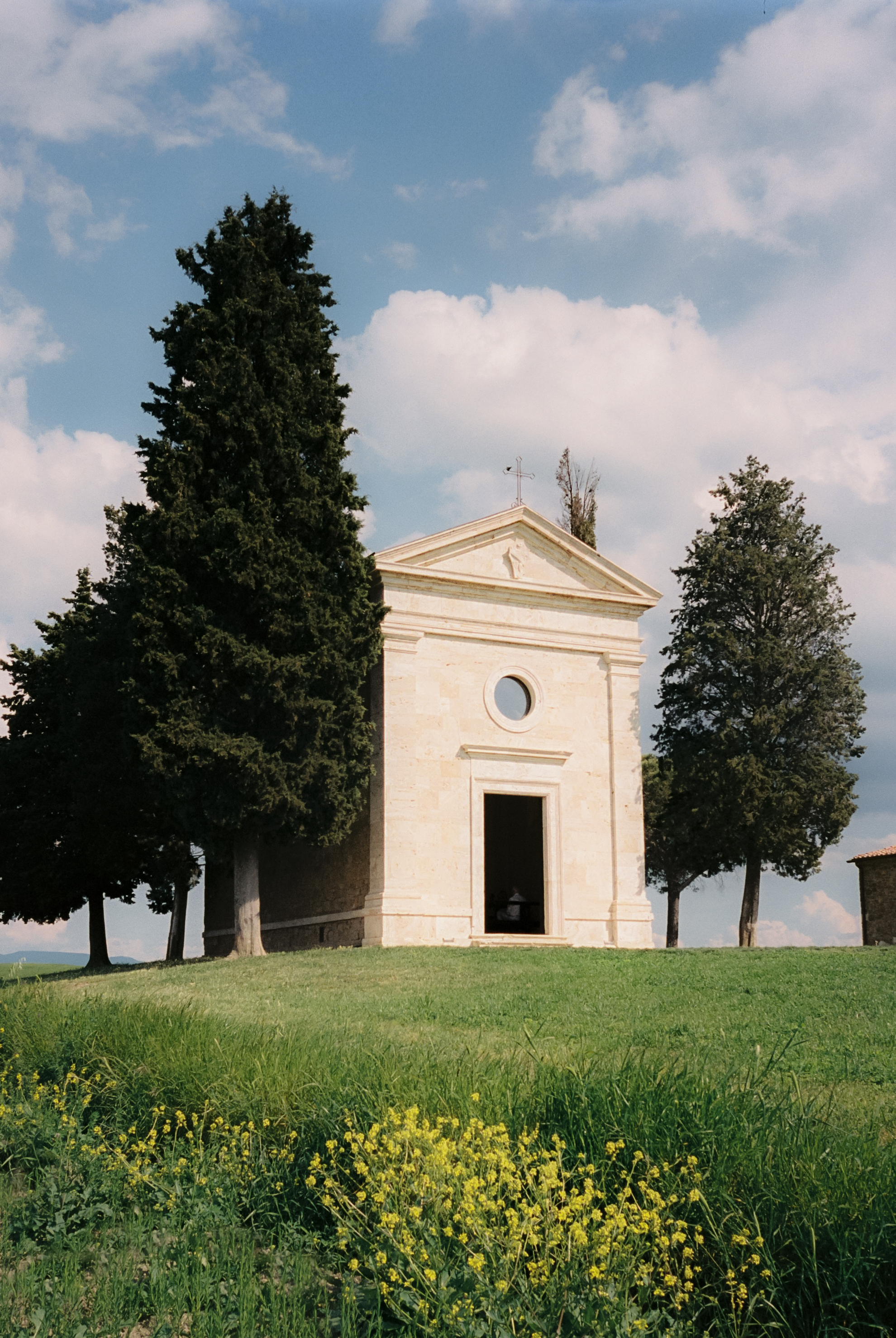 a building with a door and a window on a hill with trees