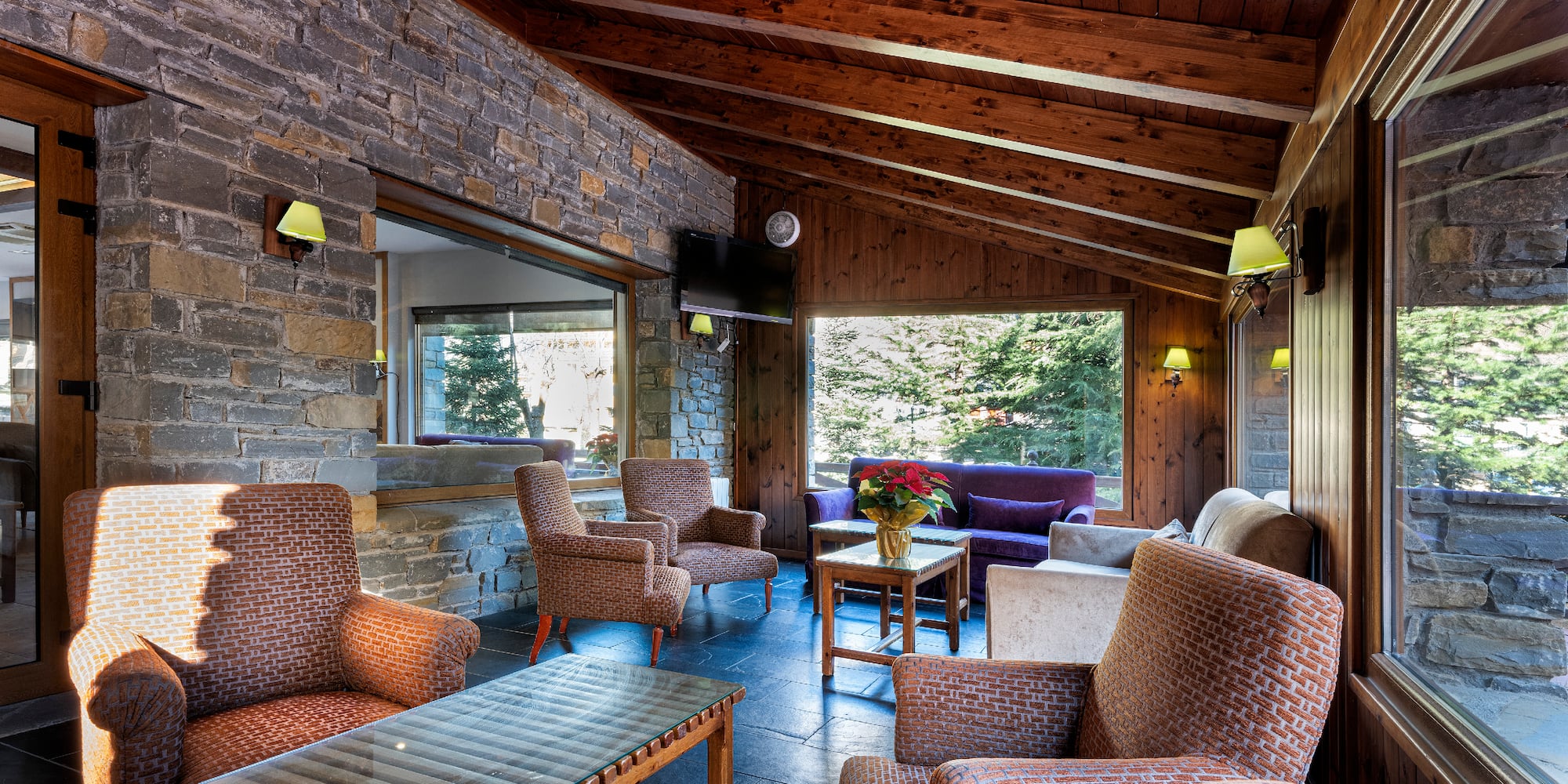 a room with a stone wall and chairs and a table