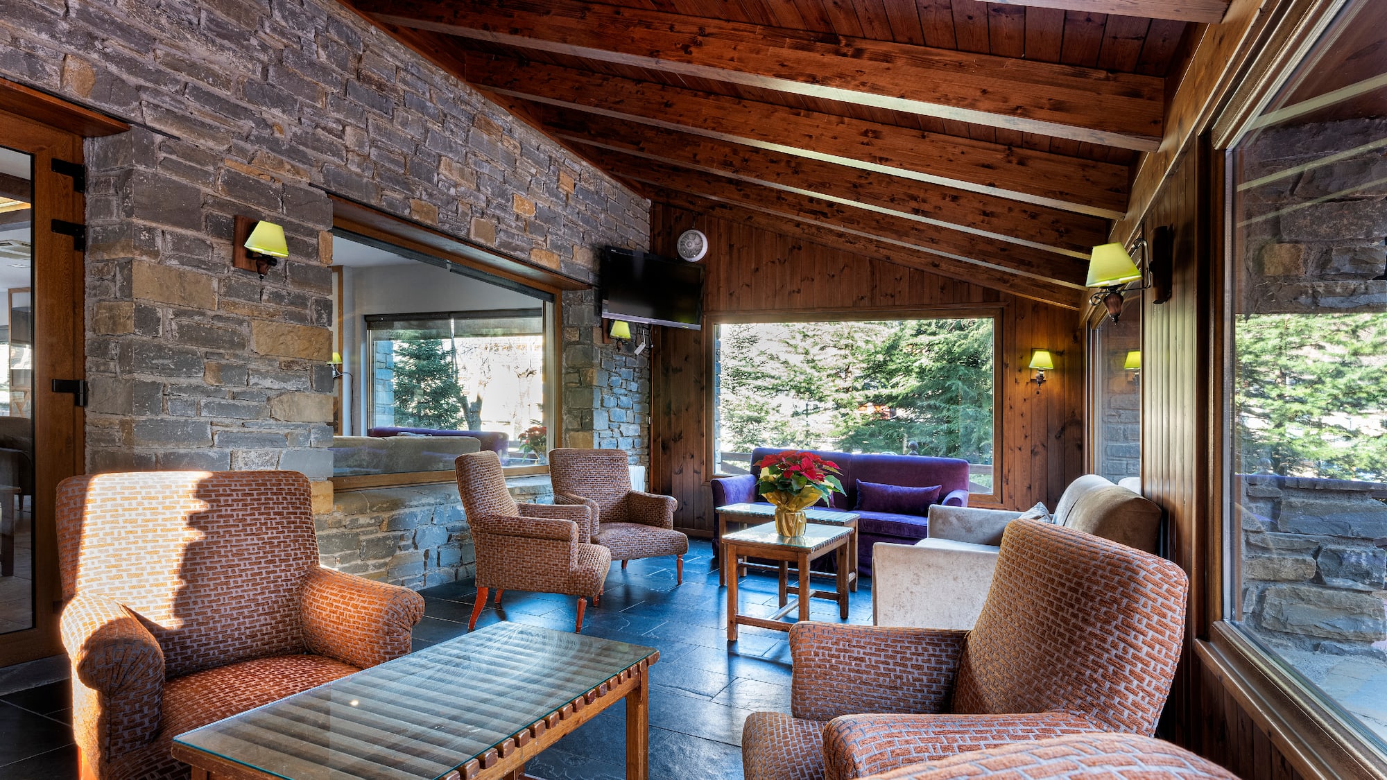 a room with a stone wall and chairs and a table