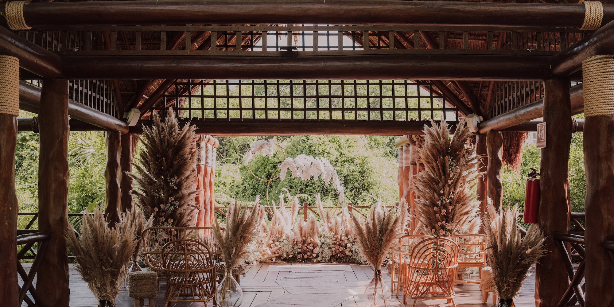 a wooden structure with chairs and grass