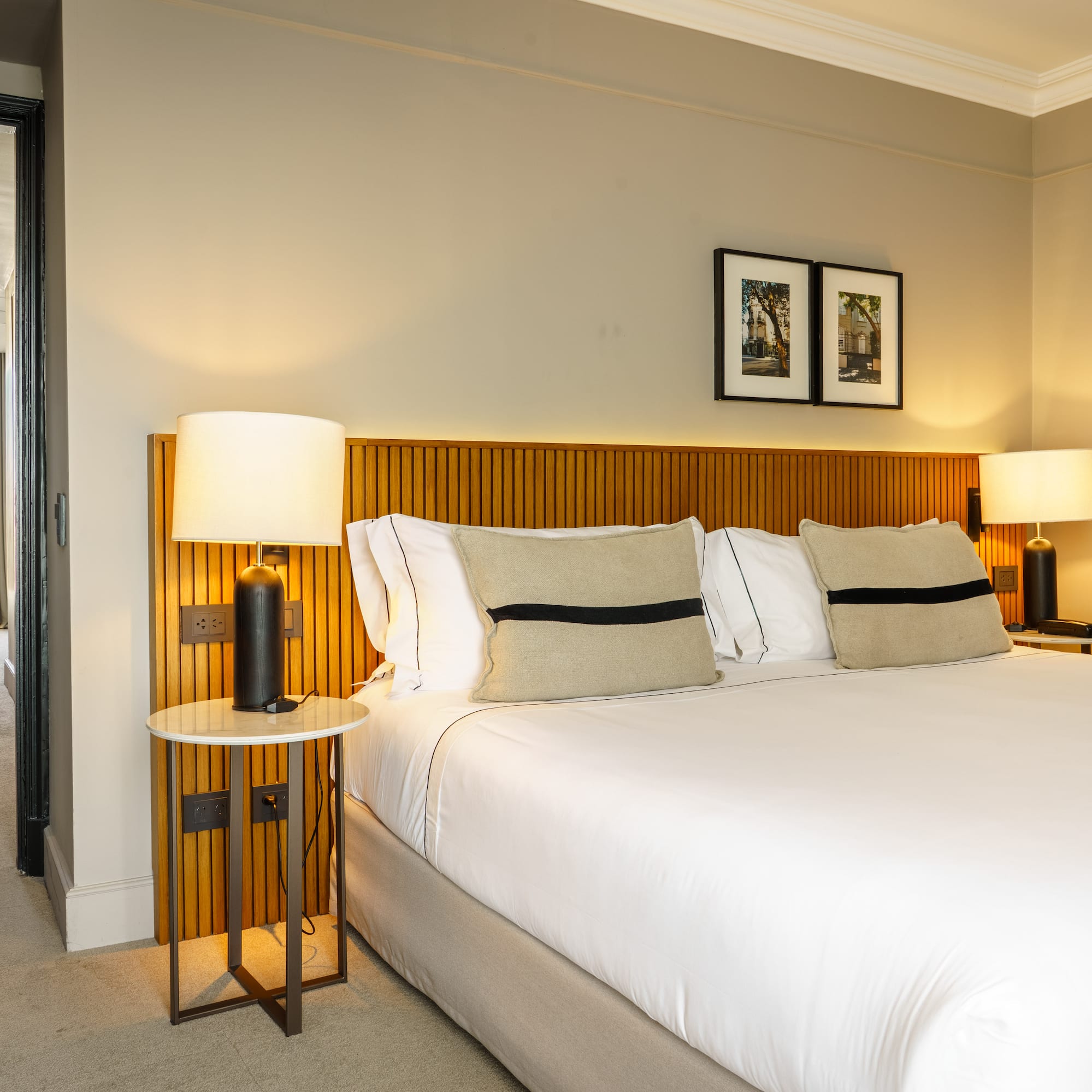 a bed with white sheets and a lamp on a side table