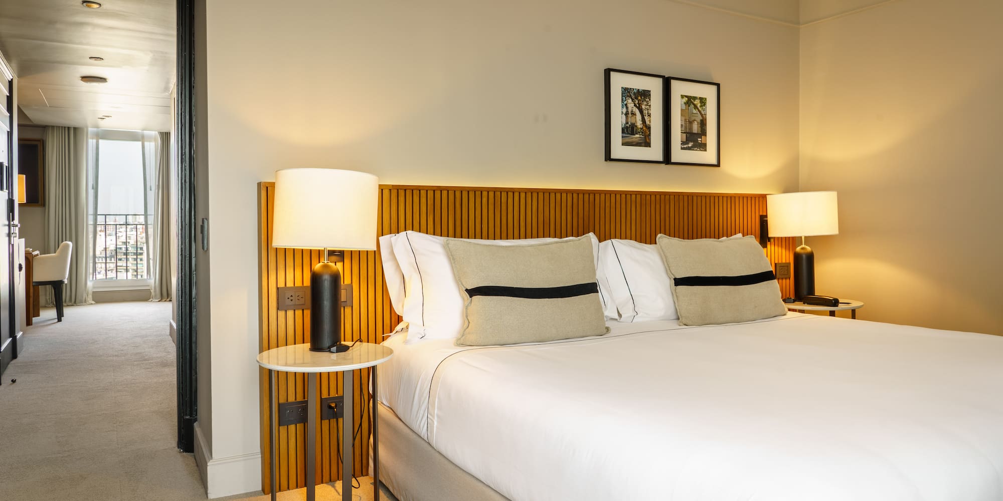 a bed with white sheets and a lamp on a side table