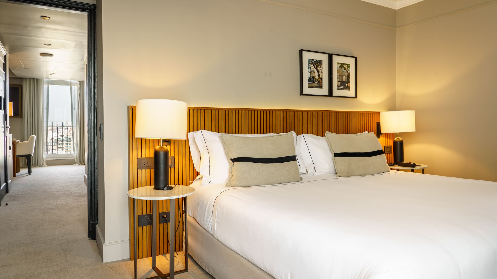 a bed with white sheets and a lamp on a side table