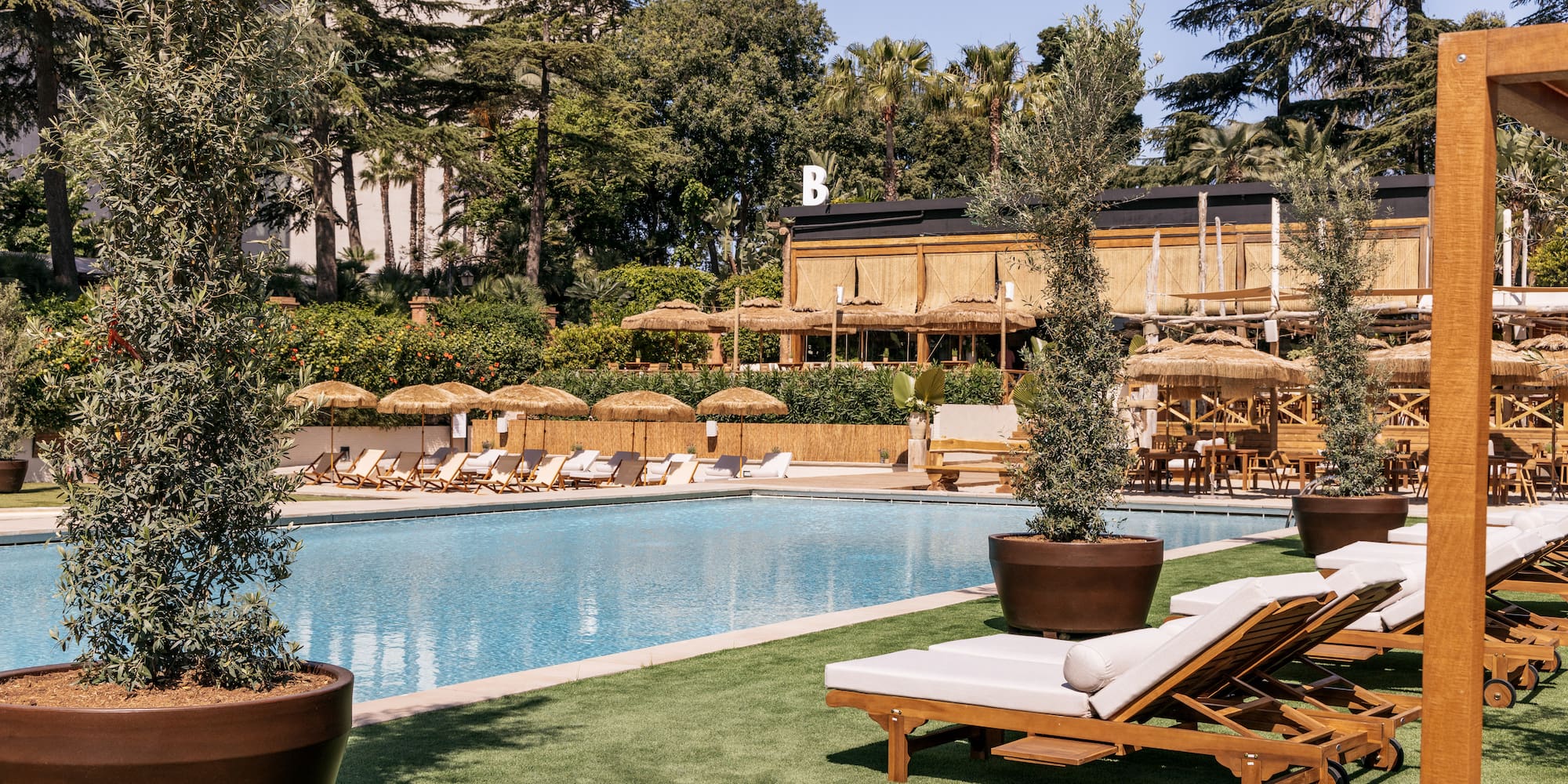 a pool with lounge chairs and trees