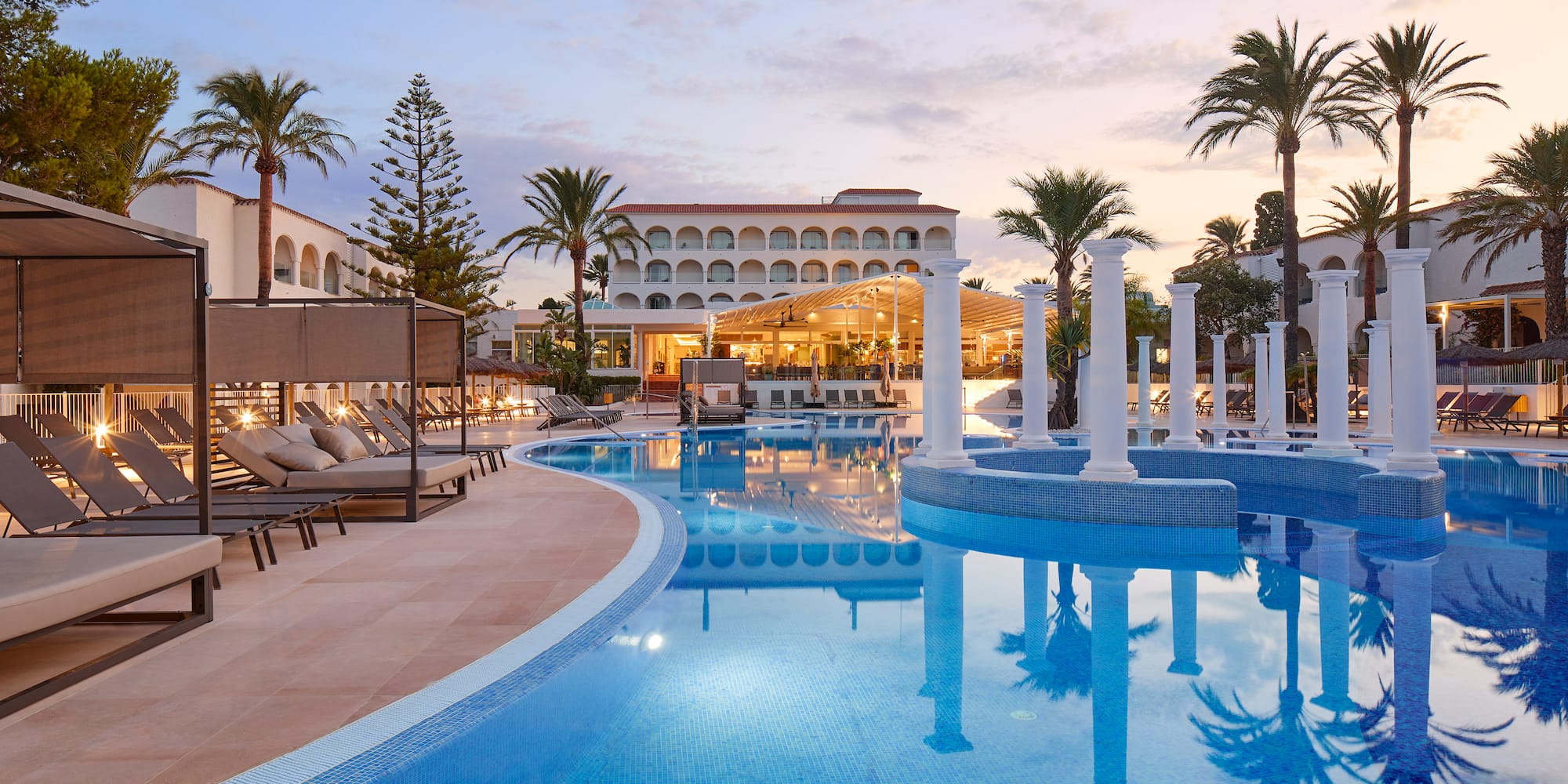 a pool with chairs and a building in the background