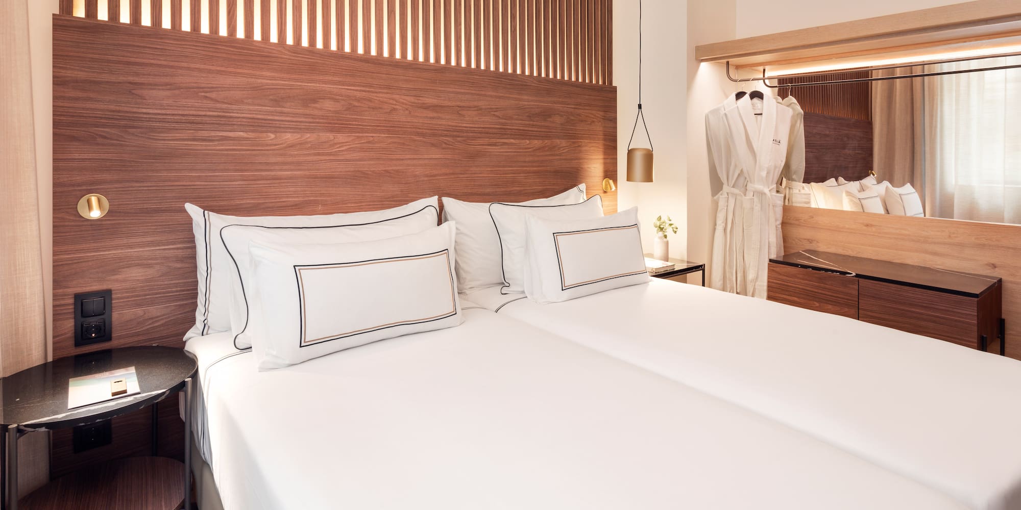 a bed with white sheets and a wooden headboard