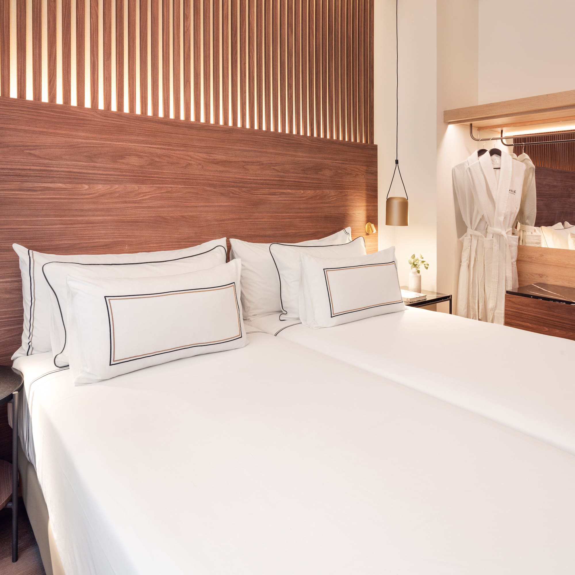 a bed with white sheets and a wooden headboard