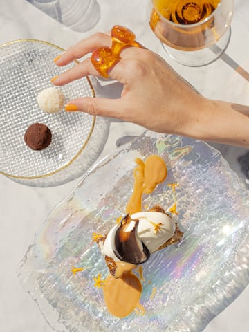 a hand holding a plate of dessert