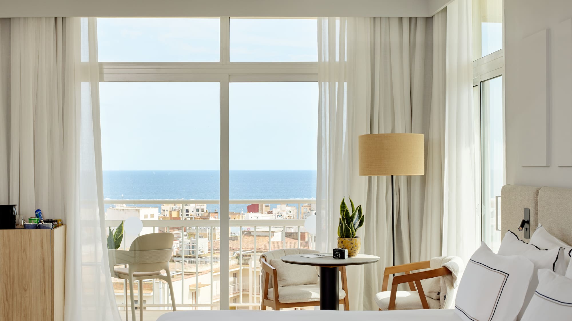 a room with a view of the ocean and a table and chairs
