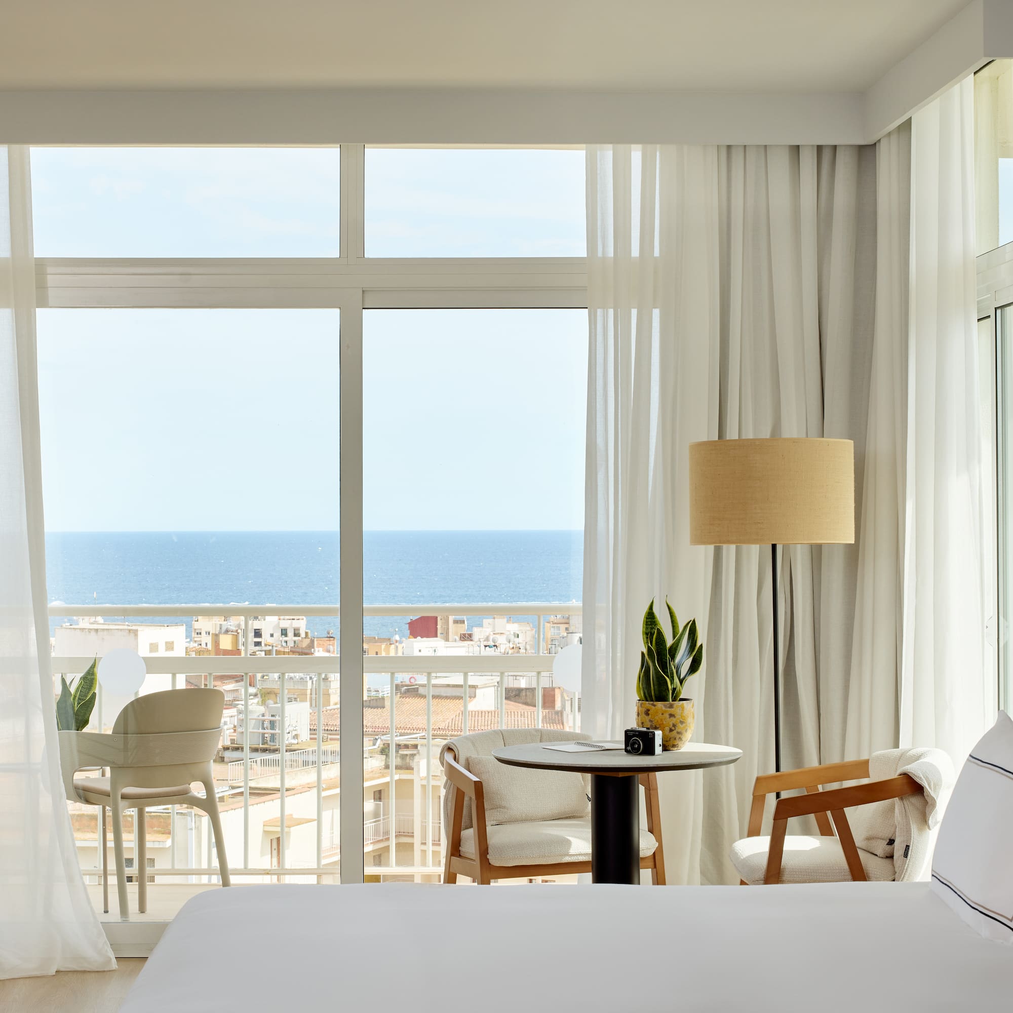 a room with a view of the ocean and a table and chairs