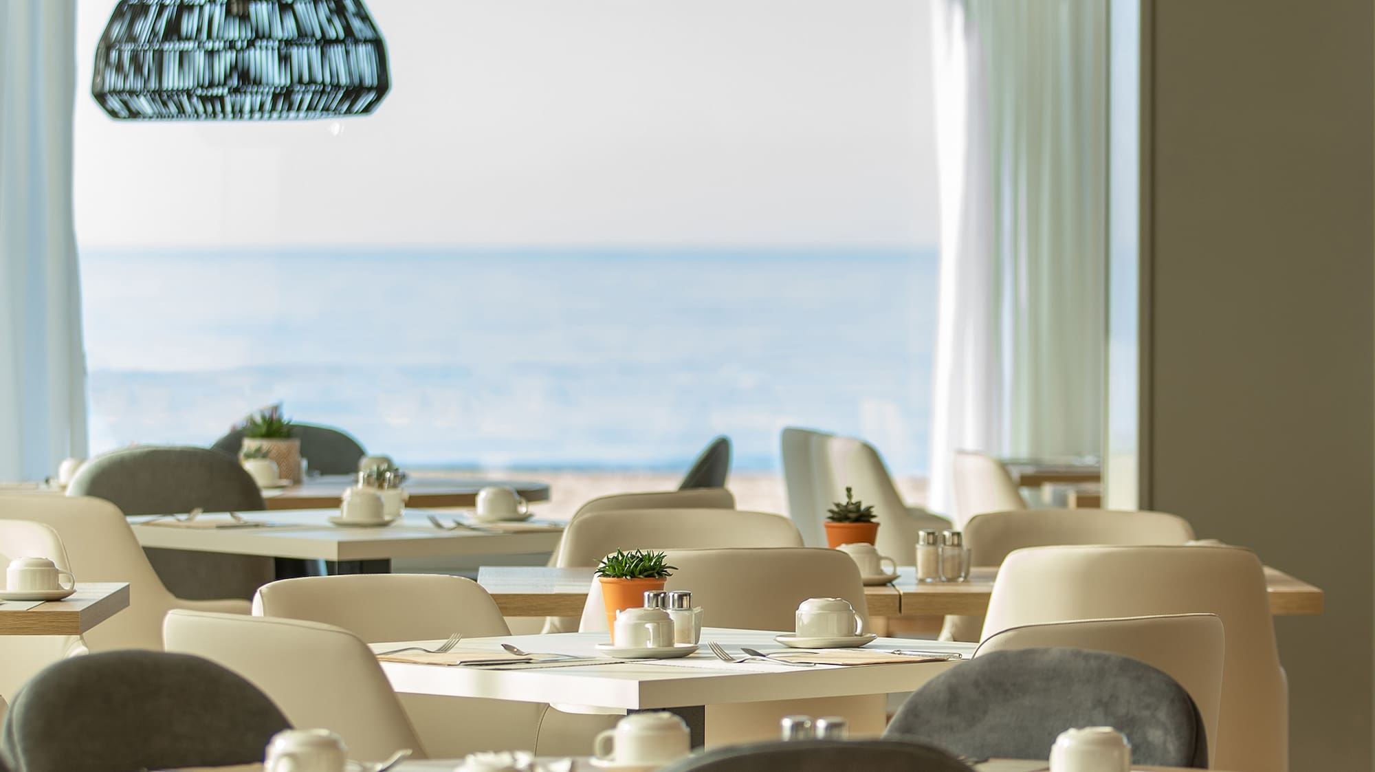 a room with tables and chairs and a large window