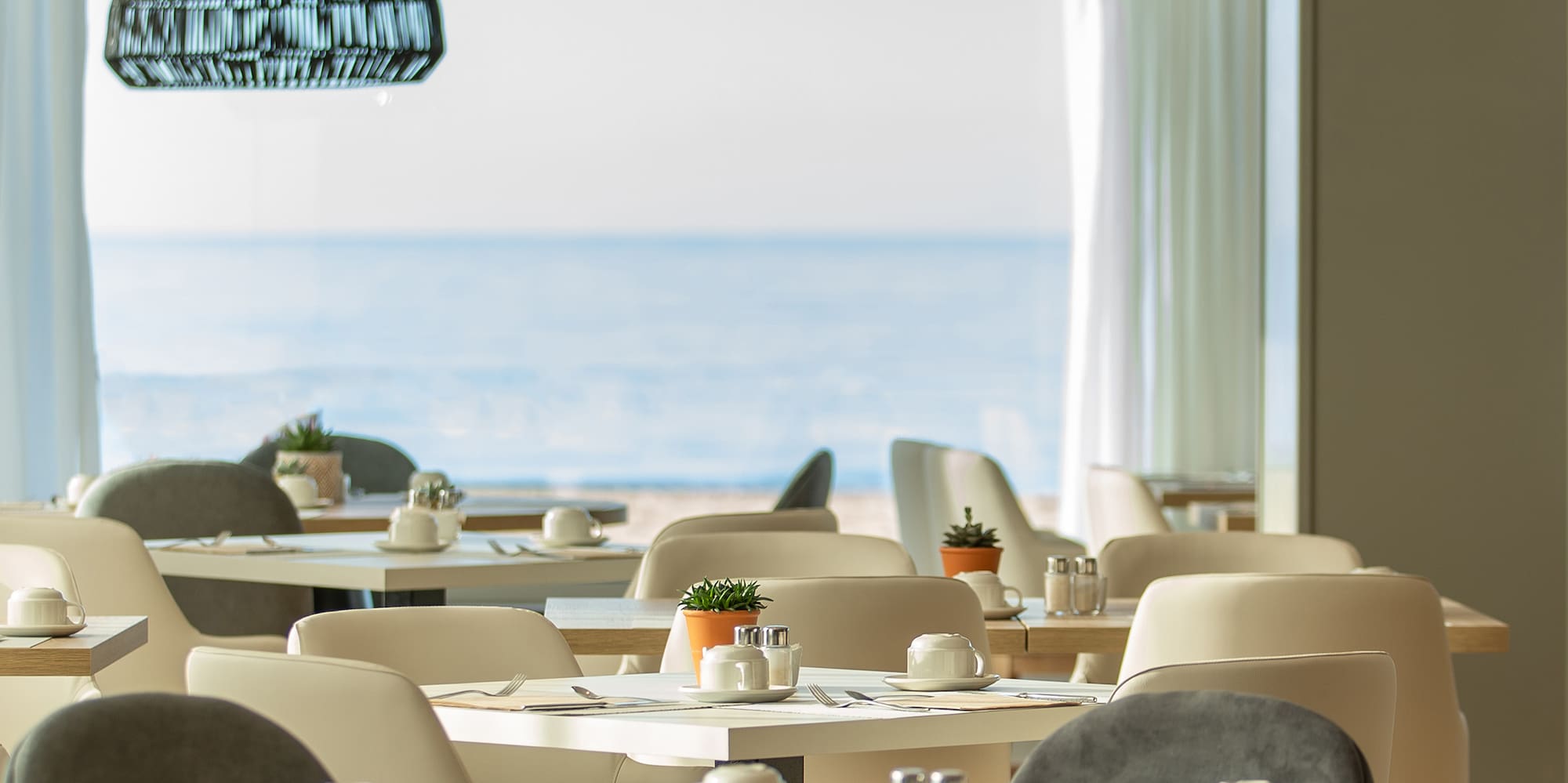 a room with tables and chairs and a large window