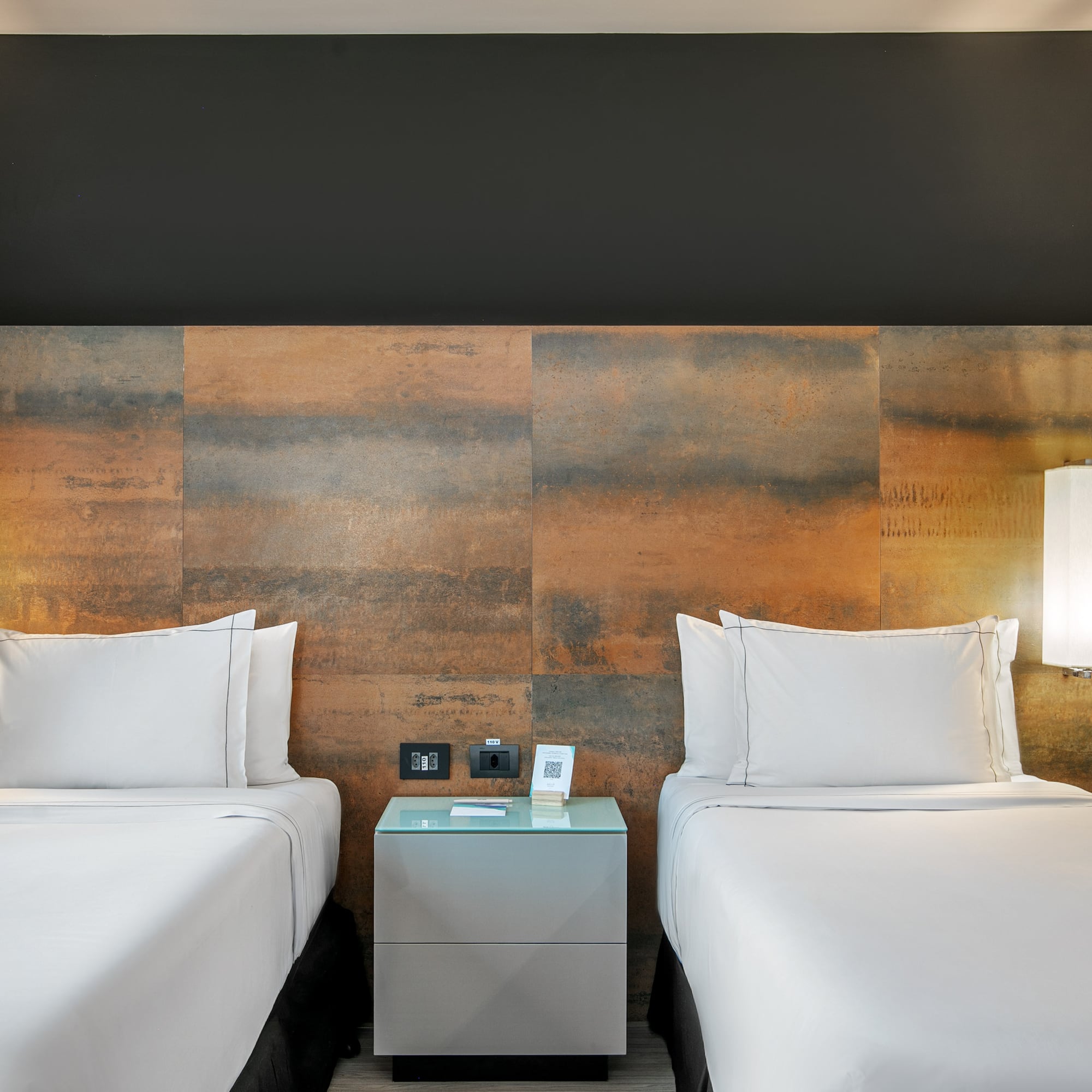 Quarto de hotel moderno com duas camas de solteiro e cabeceira de metal oxidado. - Deluxe Room Twin - Meliá Ibirapuera, São Paulo