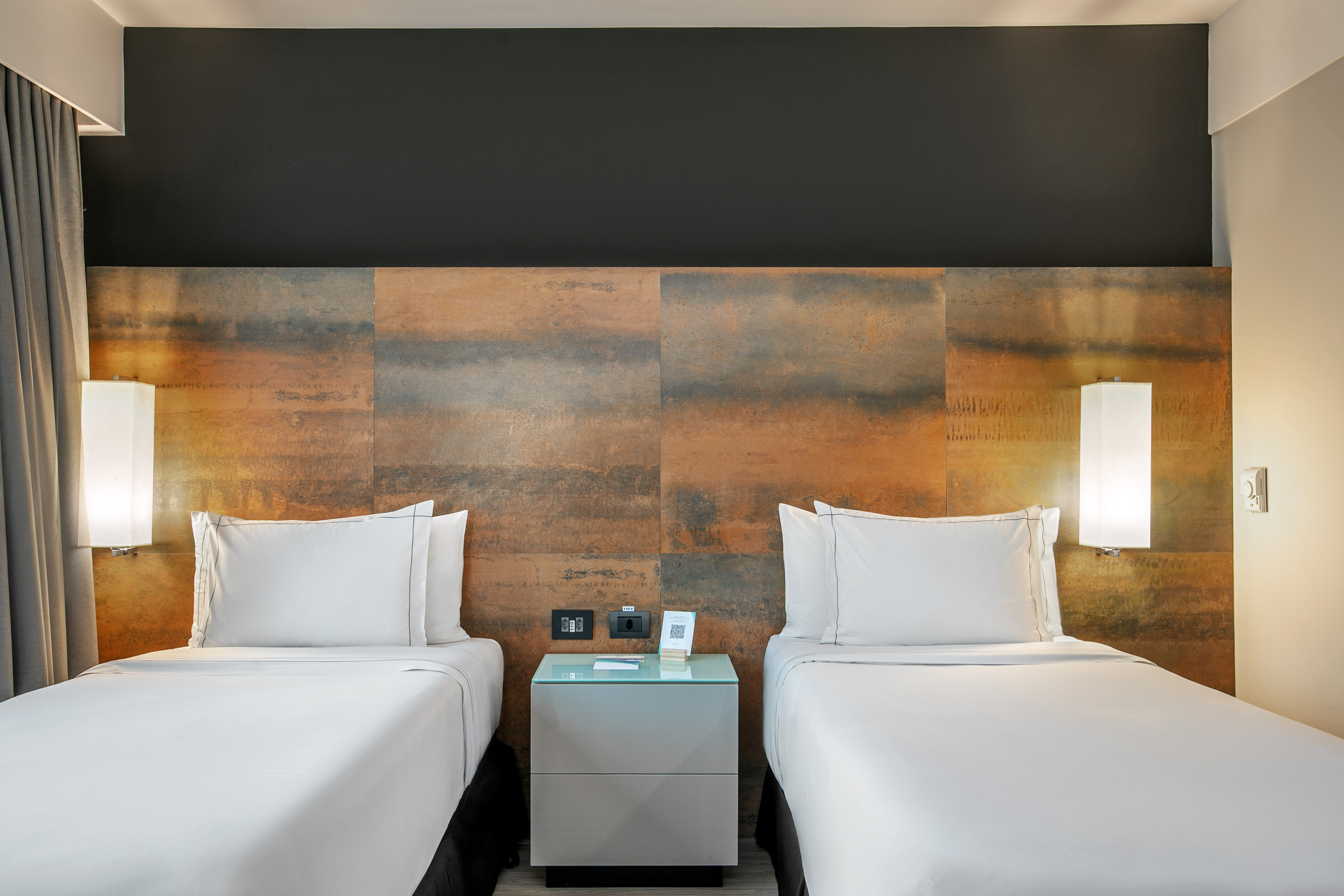 Quarto de hotel moderno com duas camas de solteiro e cabeceira de metal oxidado. - Deluxe Room Twin - Meliá Ibirapuera, São Paulo