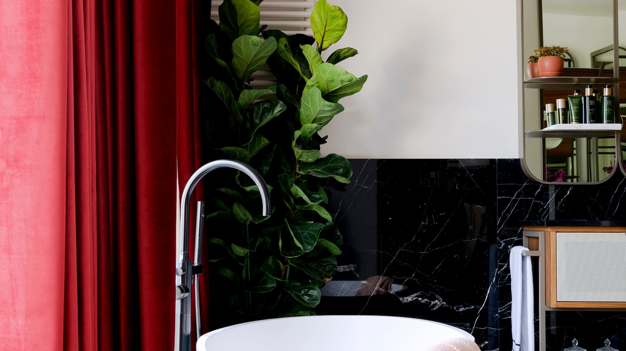 a bathroom with a tub and a red curtain