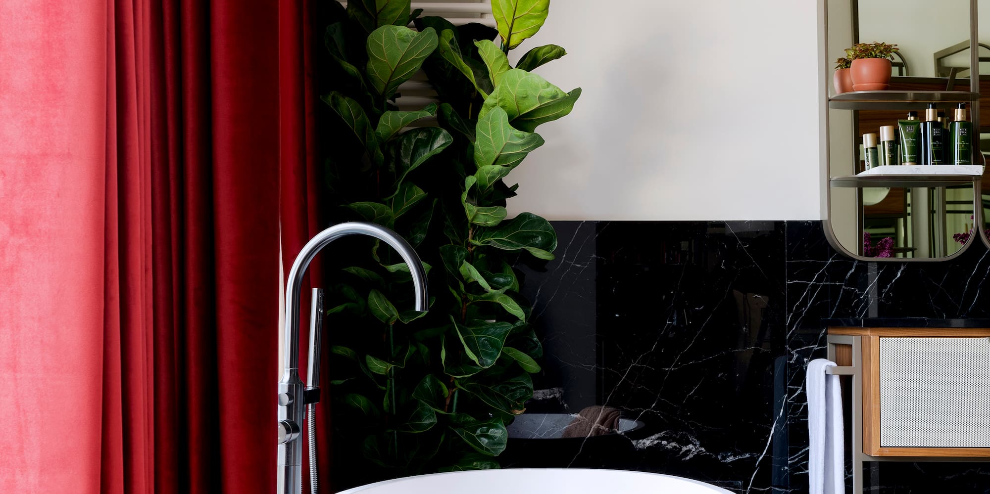 a bathroom with a tub and a red curtain