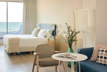 a room with a bed and a table and chairs