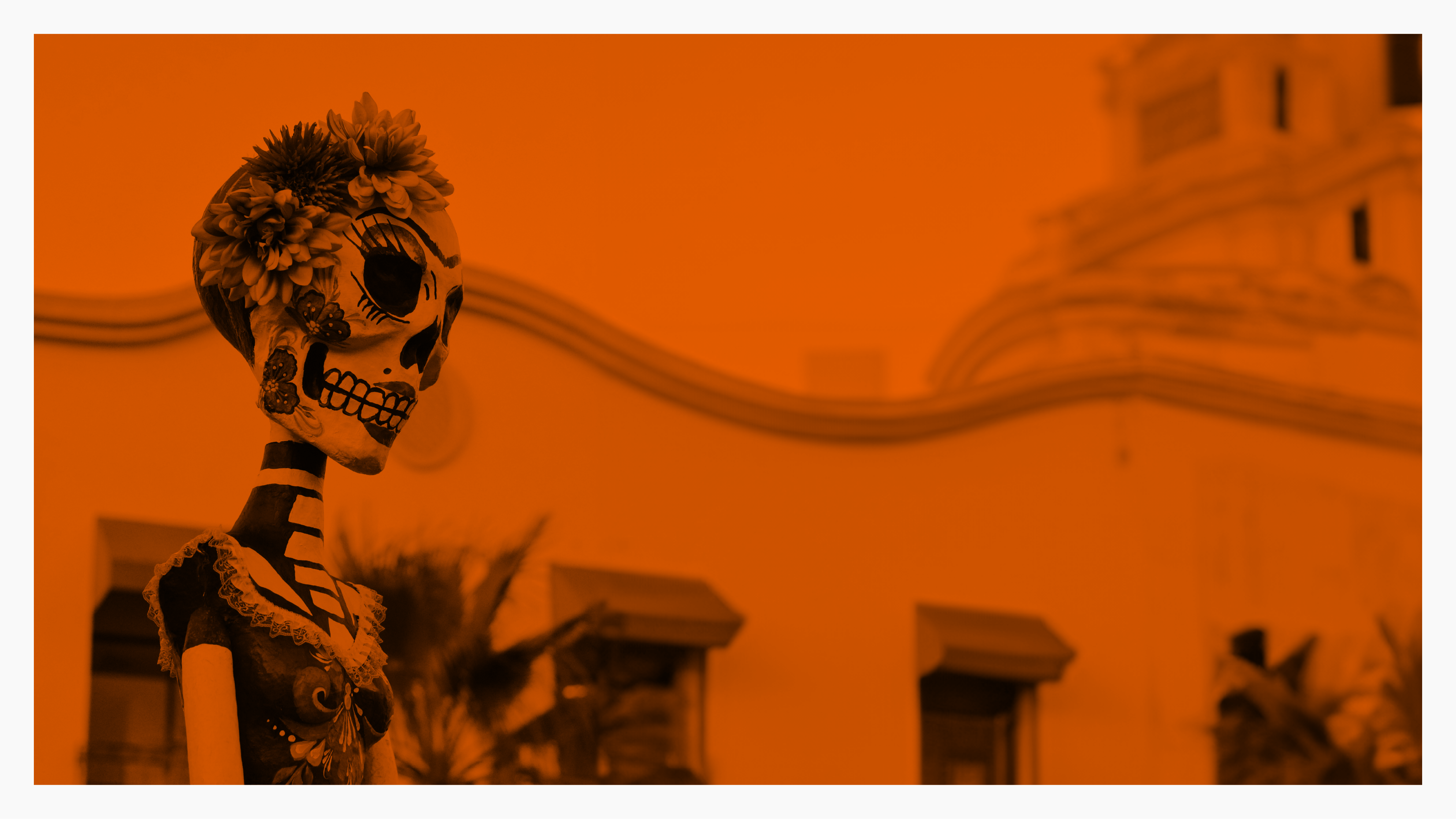 a skeleton with flowers in front of a building