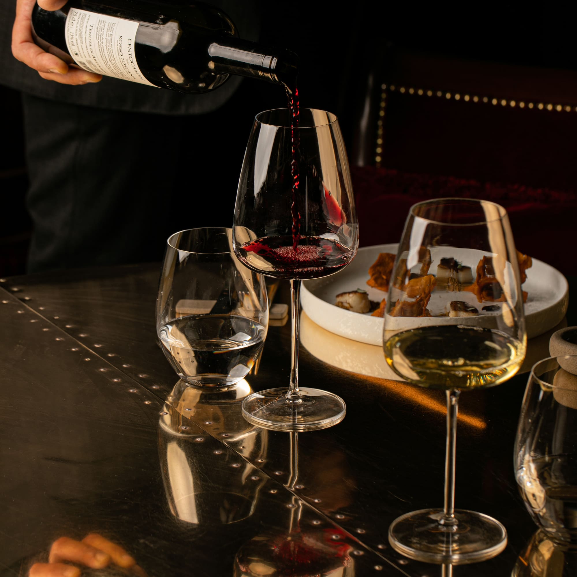 a person pouring wine into a glass