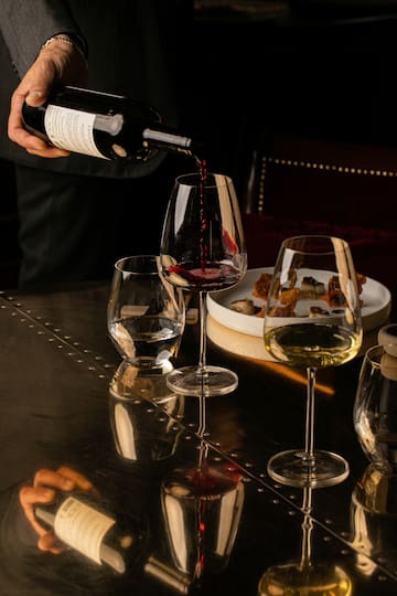 a person pouring wine into a glass