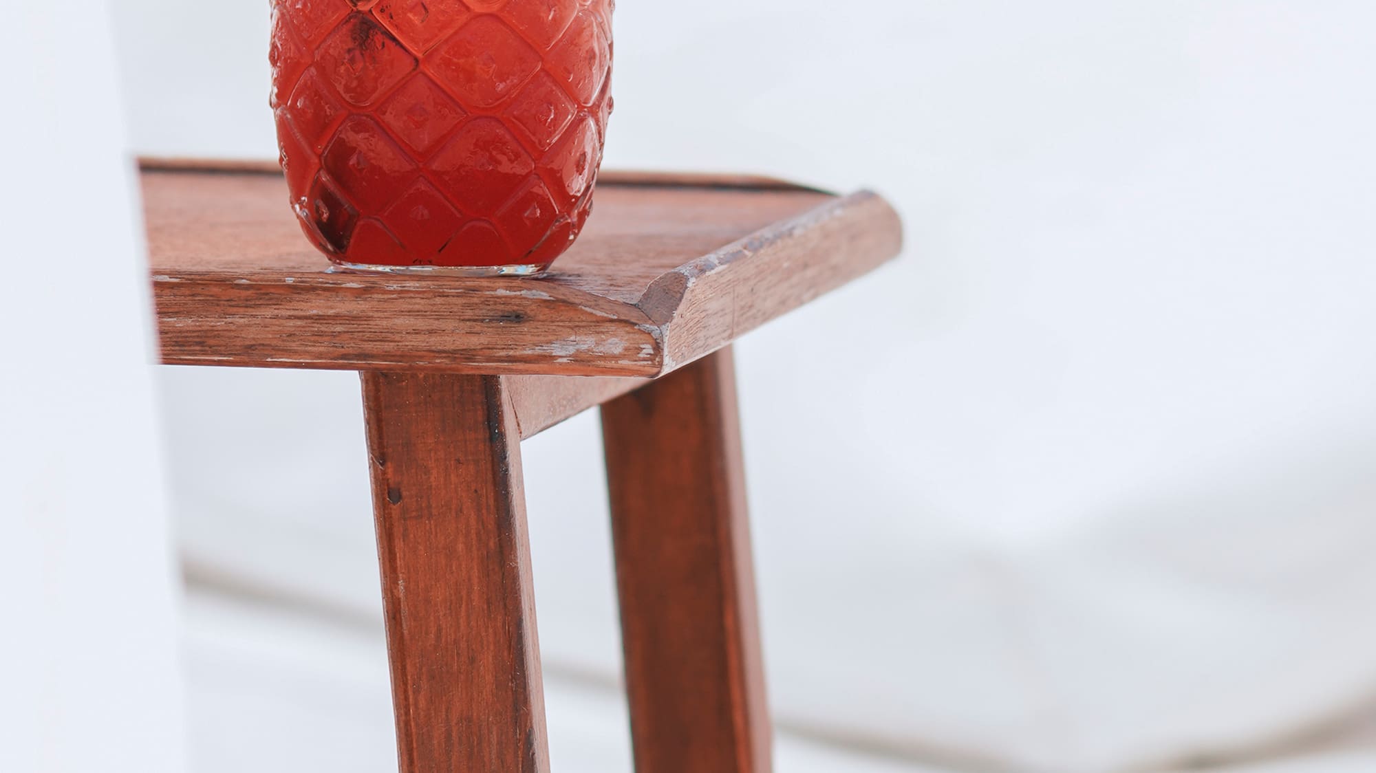 a glass of red liquid on a table