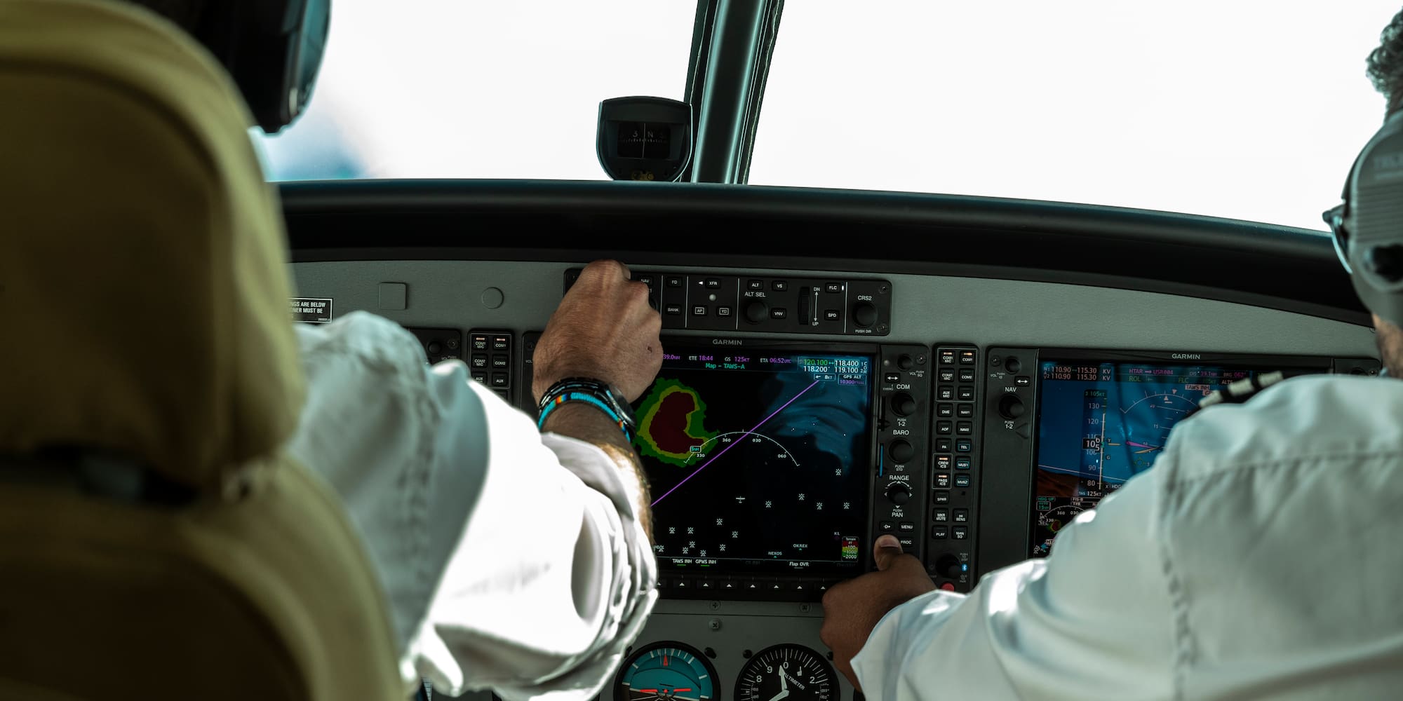 a man in a white shirt and black headphones touching a screen