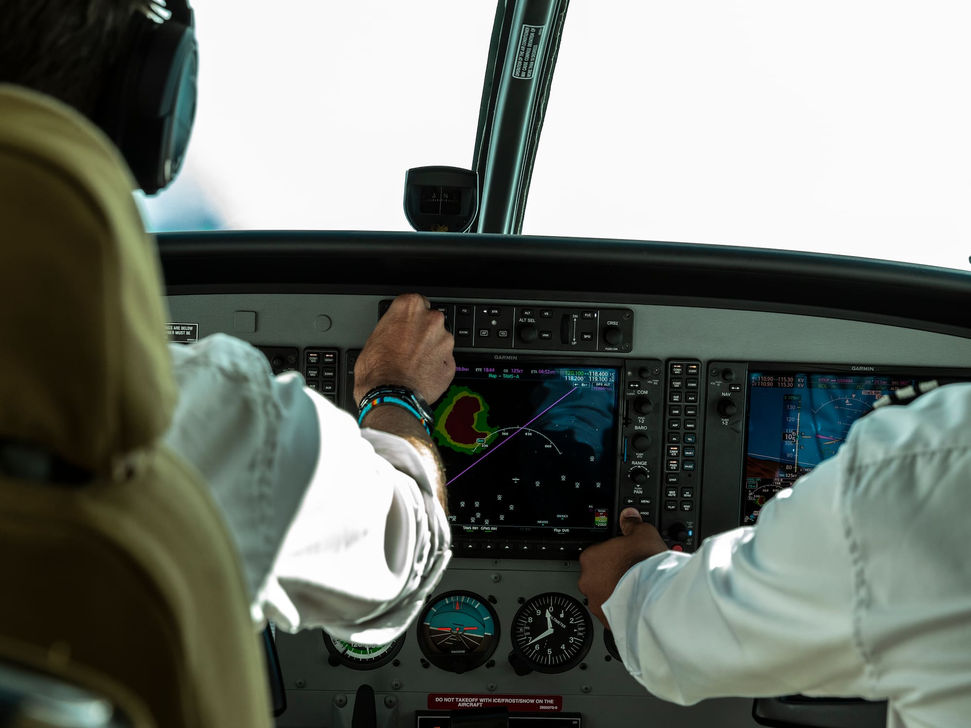 a man in a white shirt and black headphones touching a screen