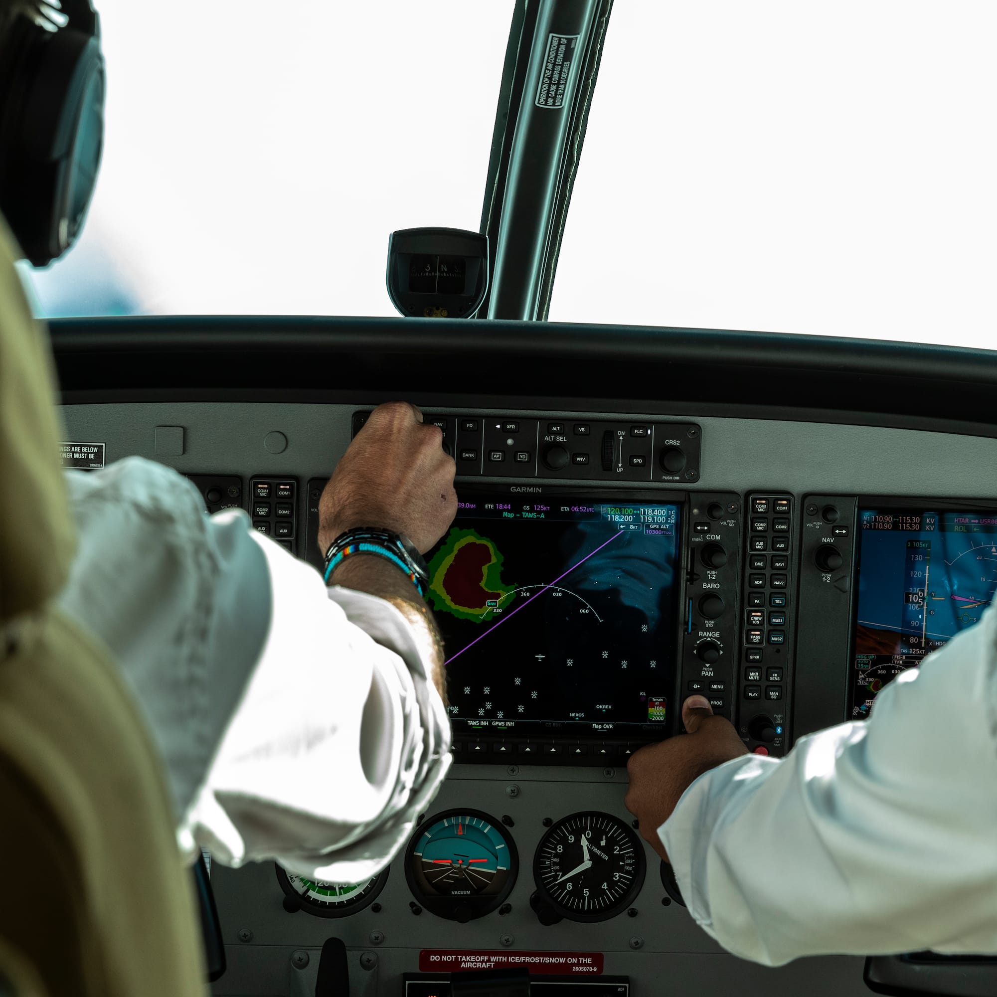 a man in a white shirt and black headphones touching a screen