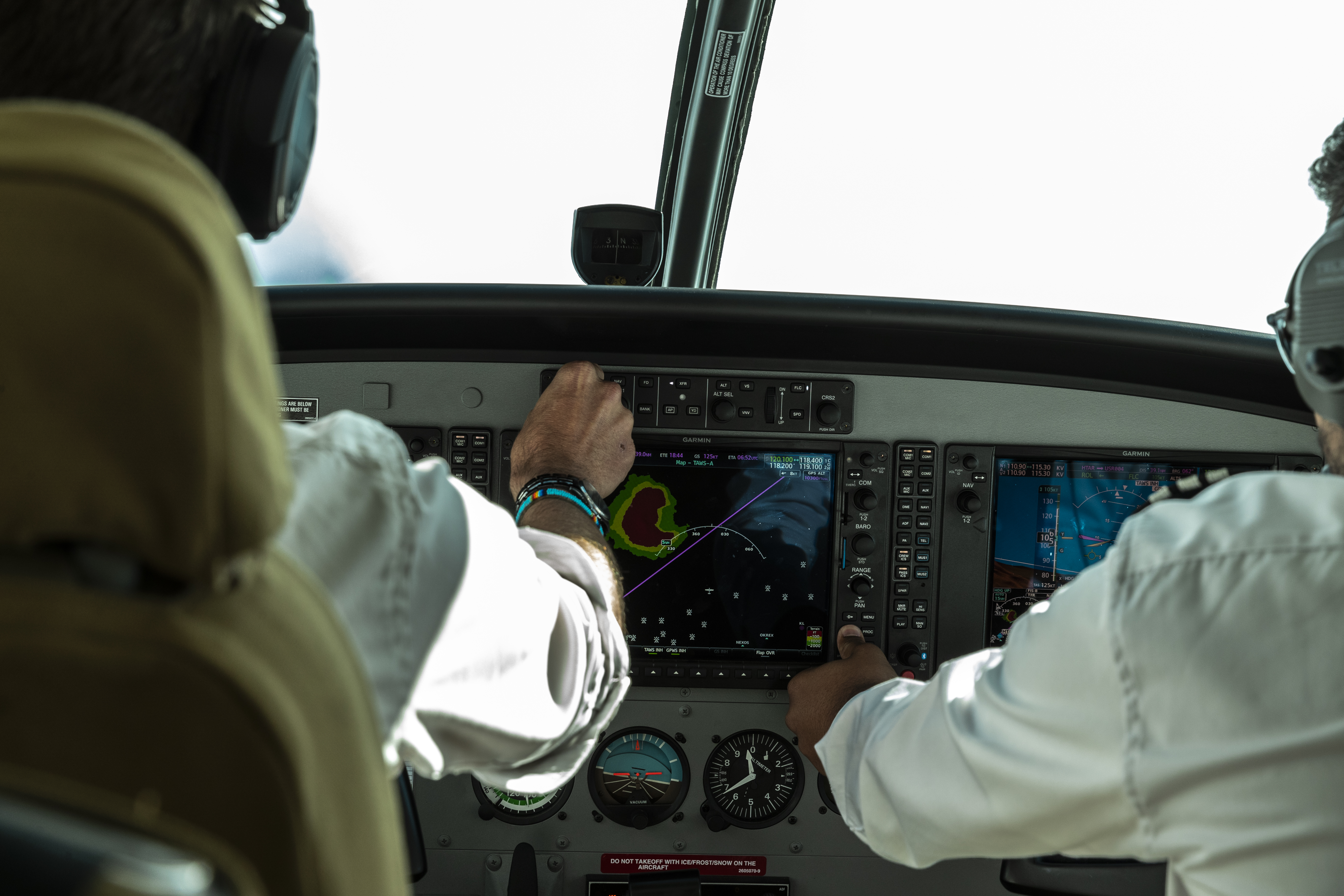 a man in a white shirt and black headphones touching a screen