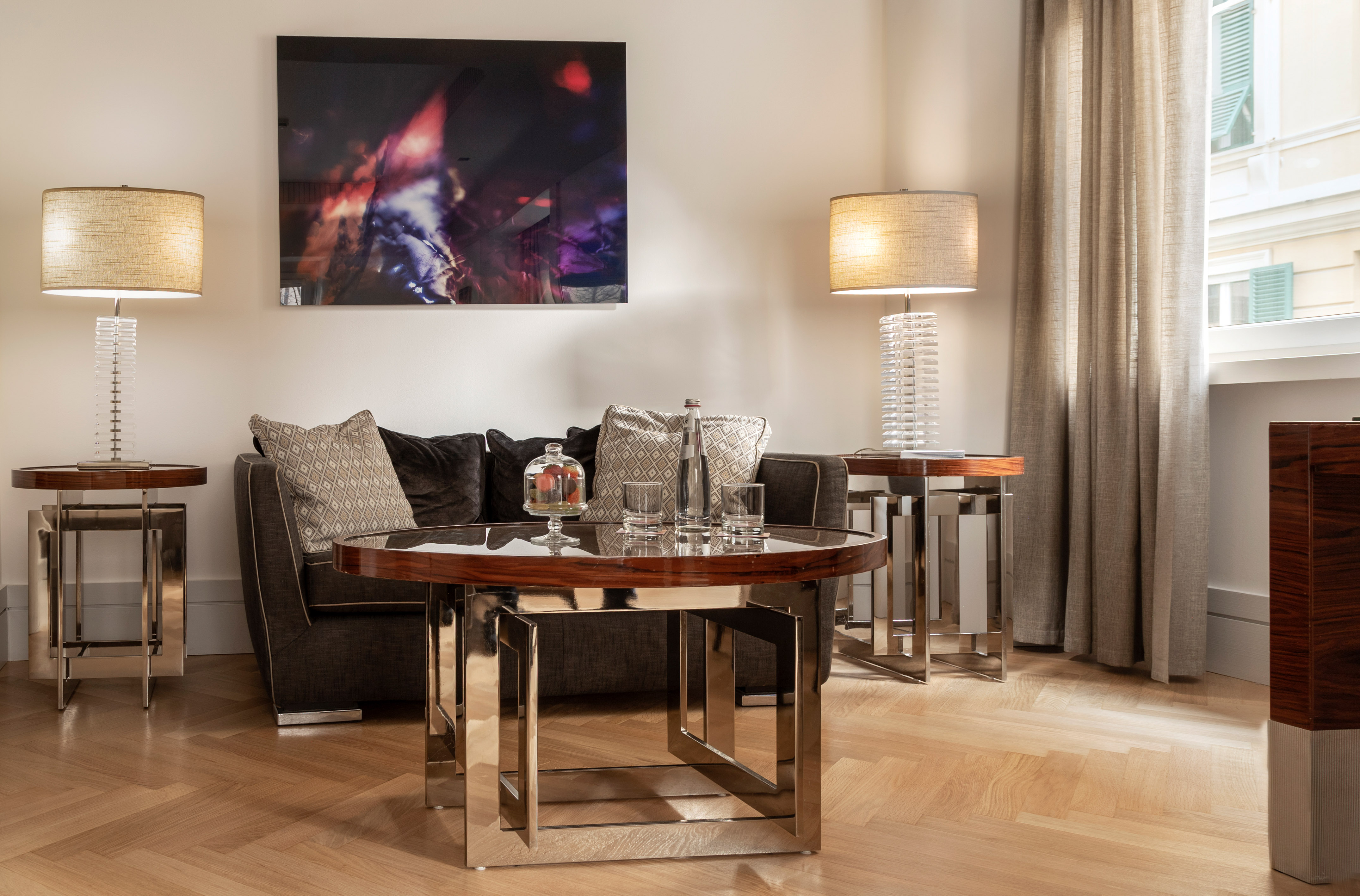 Elegant living room with sofa, modern lamps, and sleek coffee tables.