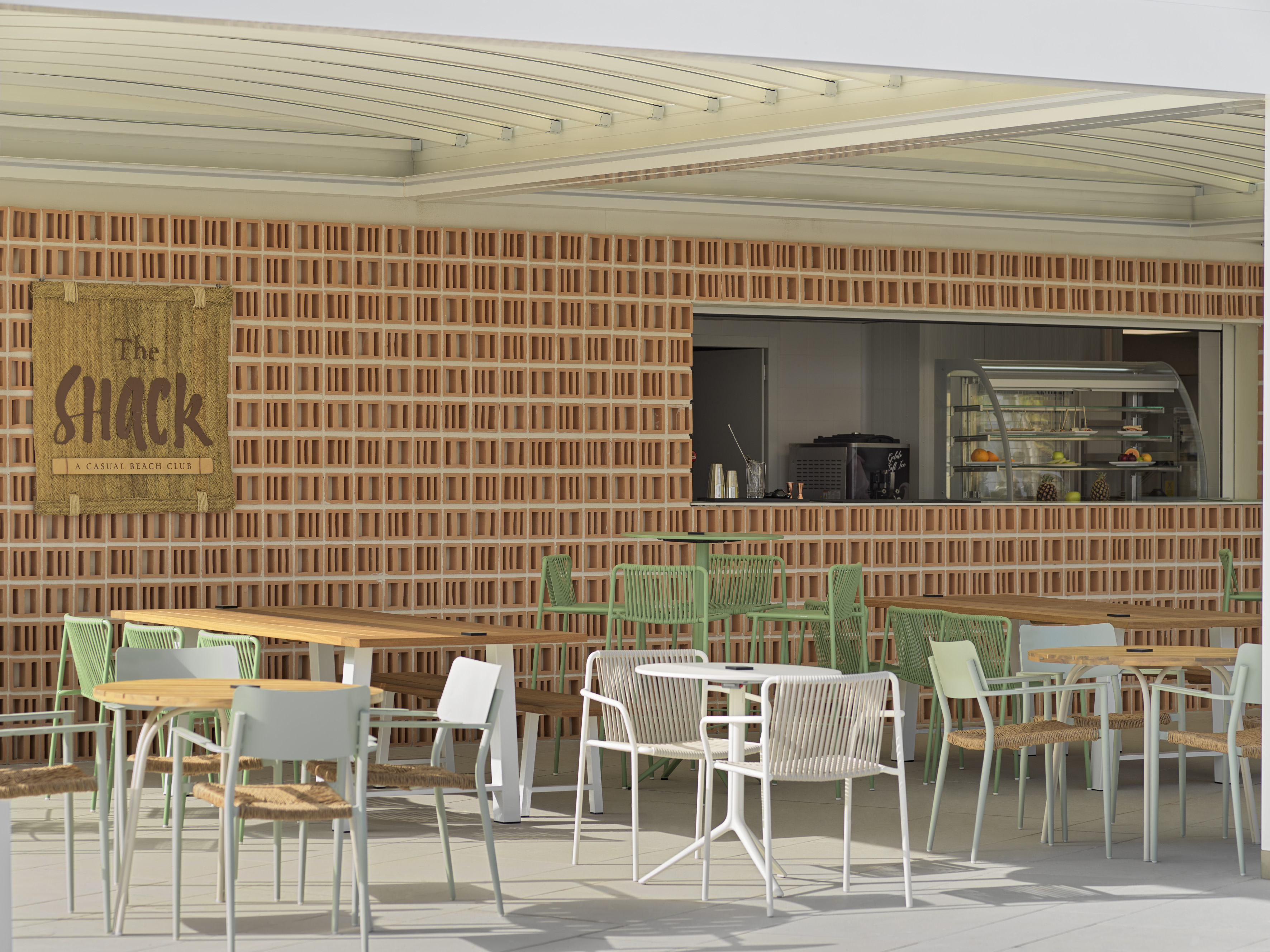 The Shack casual beach club patio, modern outdoor furniture, terracotta wall.